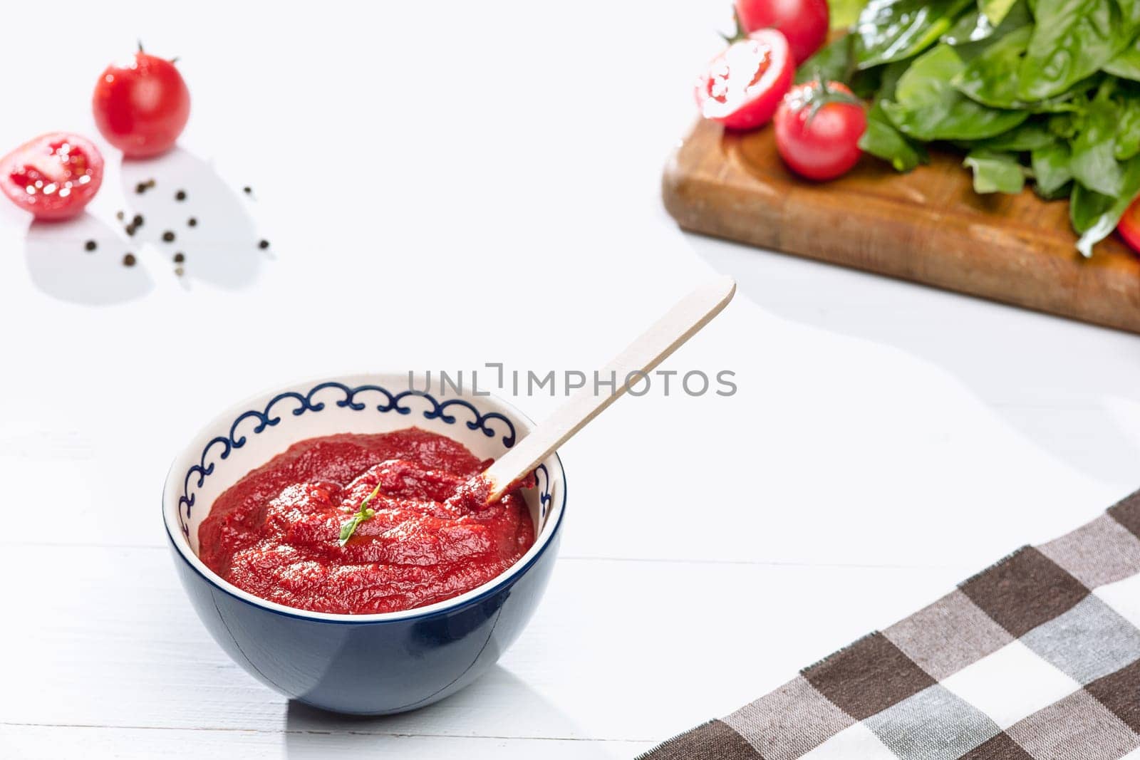 Bowl of chopped tomatoes on rustic table. Next to fresh whole tomatoes