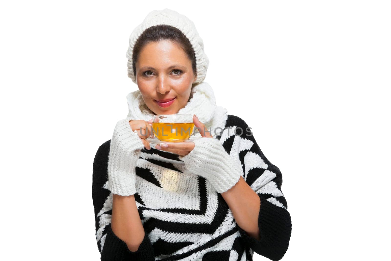 Young brunette woman with white wool lyane drinks a cup of tea to warm up isolated on white background