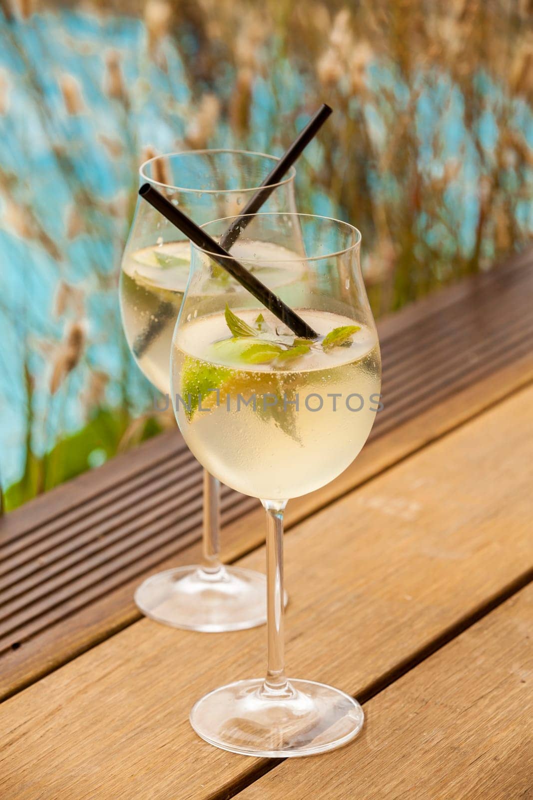 Fresh Hugo with mint lime and sparkling wine in a wine-weinin in summer by the water