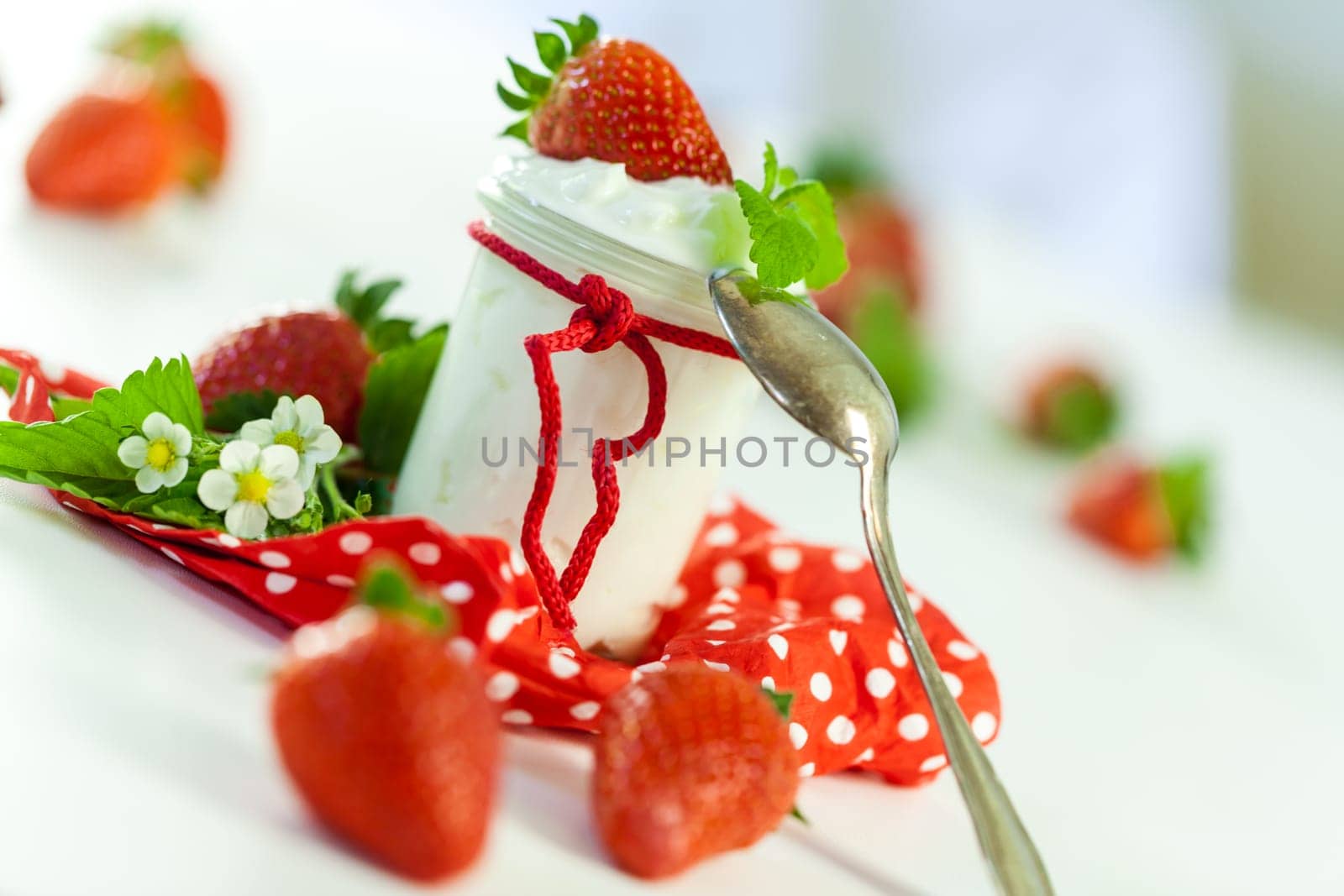 Fresh yoghurt with strawberries in a glass insulated on a white background