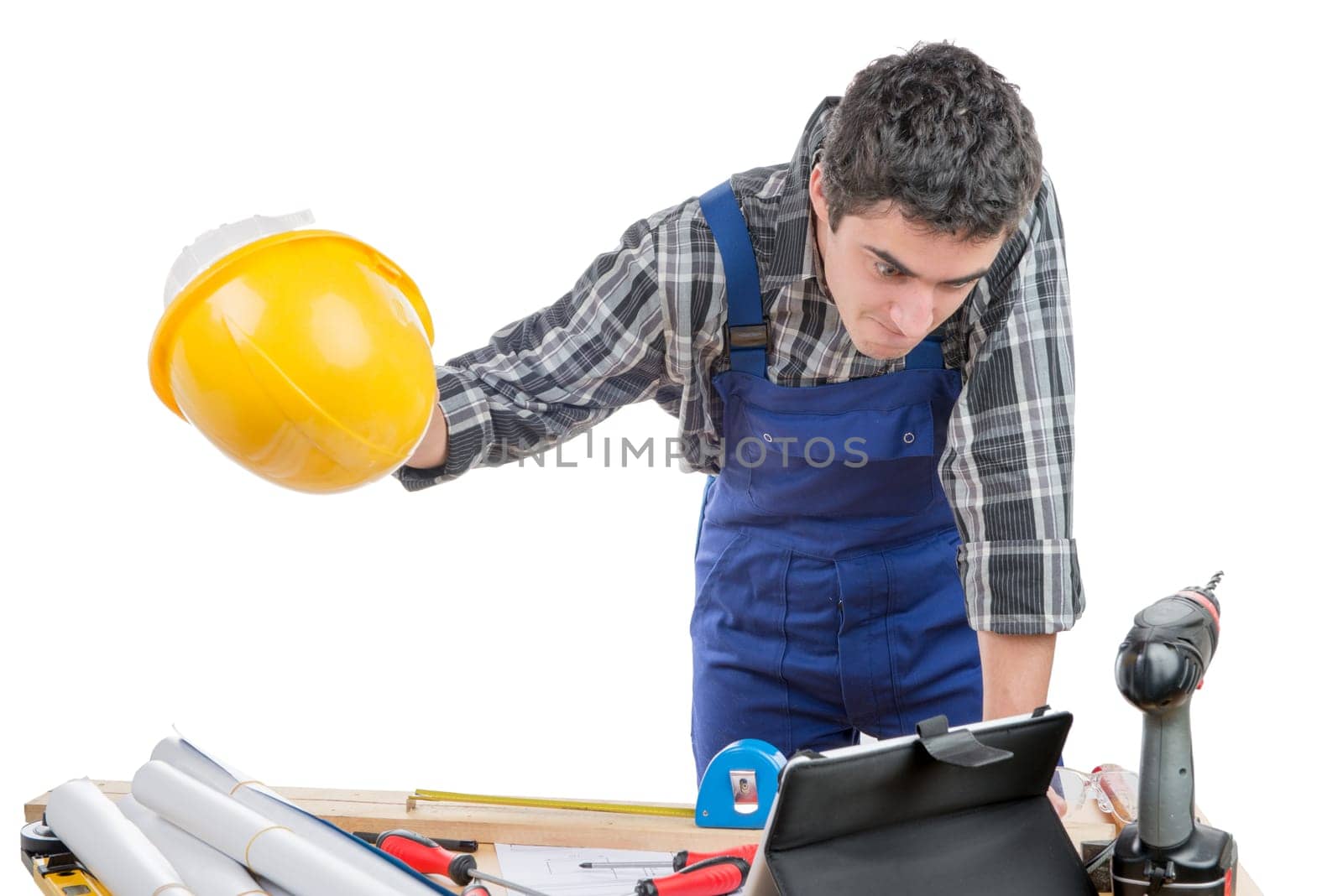 a young worker is angry and throws his helmet