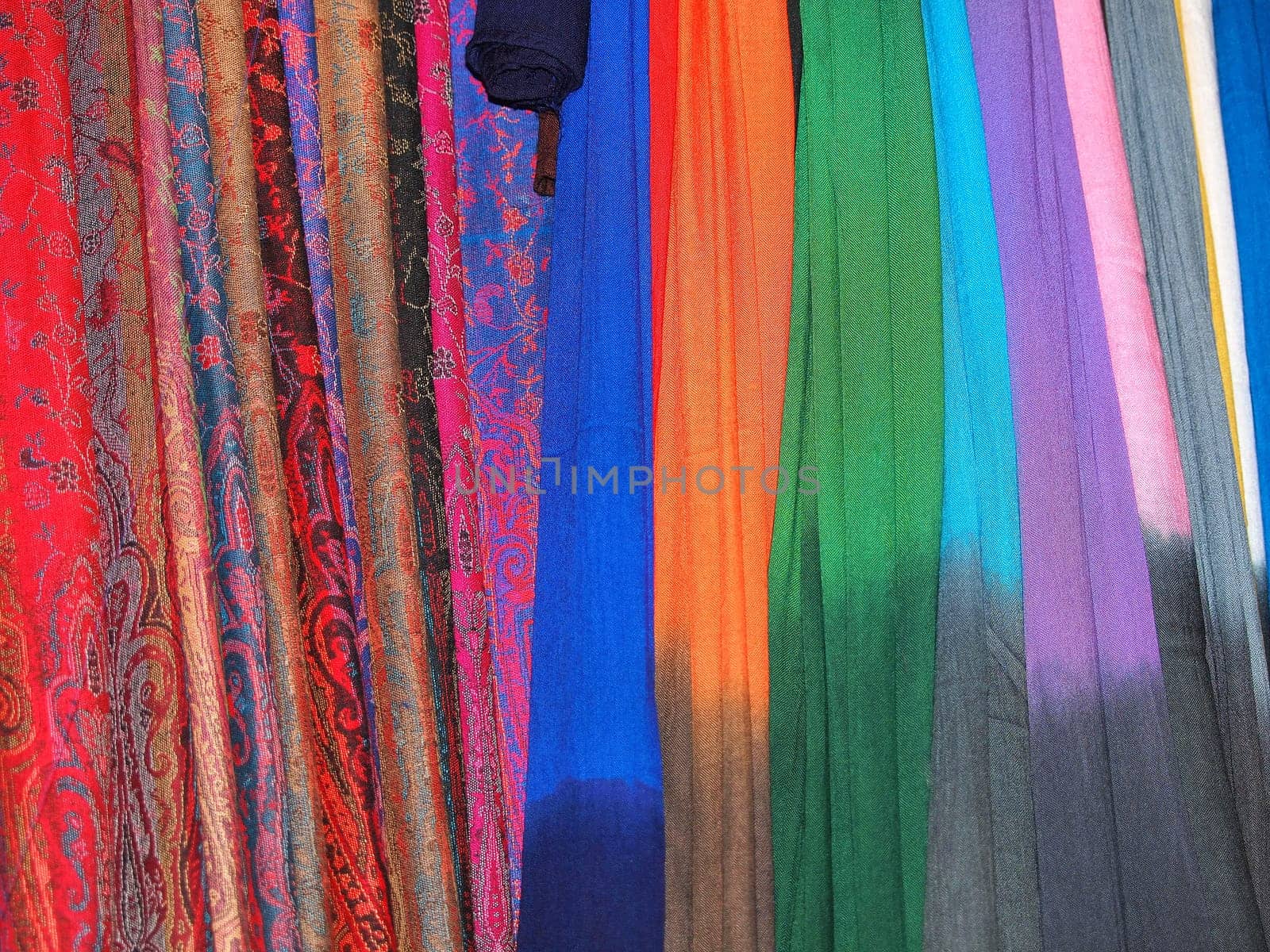 Pile of gentle folded shawls (scarfs) hanging at the market