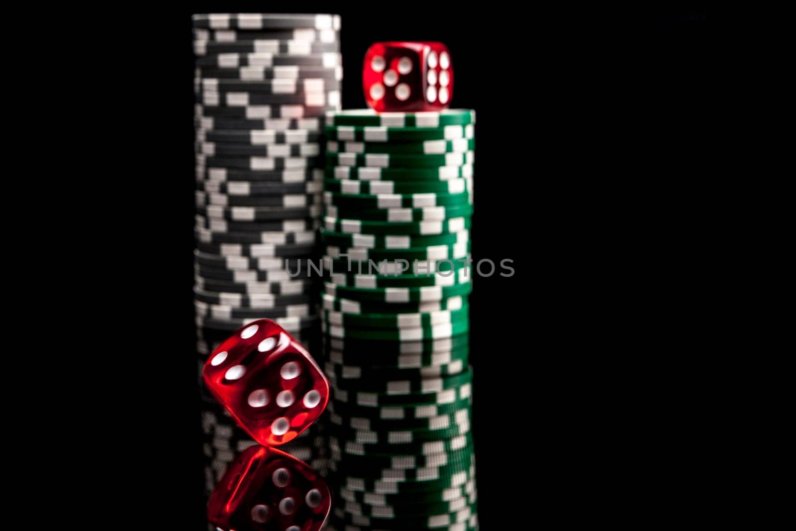 Dice and chips isolated on black background with reflexion