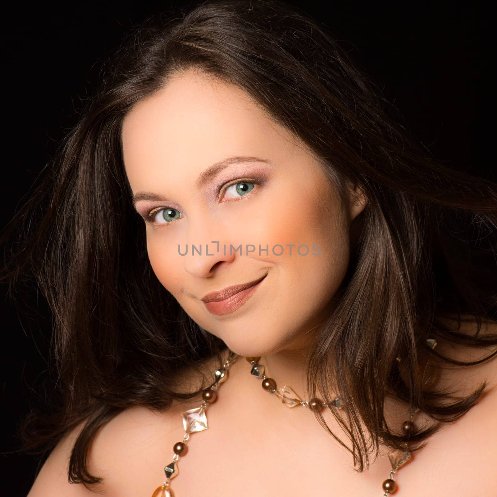 Portrait about a smiling woman on black background.