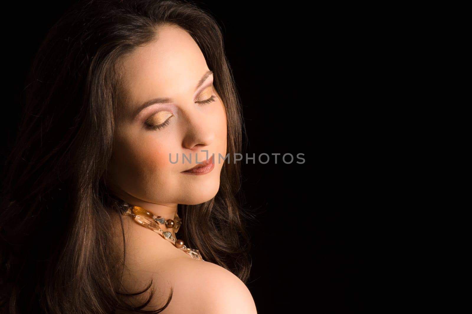 Beauty portrait about a woman with make-up on black background.