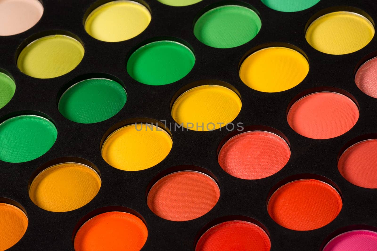 Eye shadow palette with differente colors on black background.