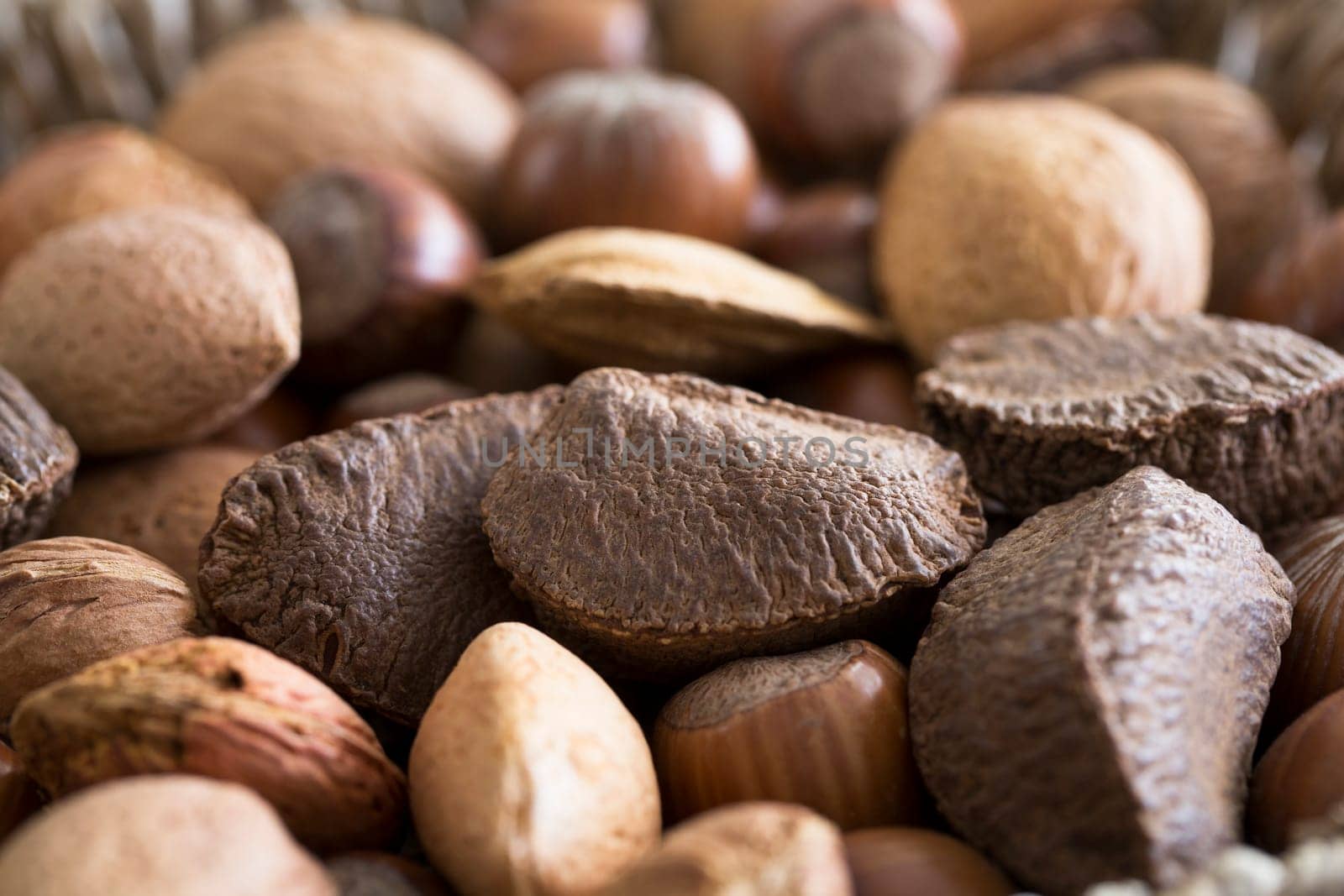 Mixed whole nuts in shell close up with Brazil nut in focus.