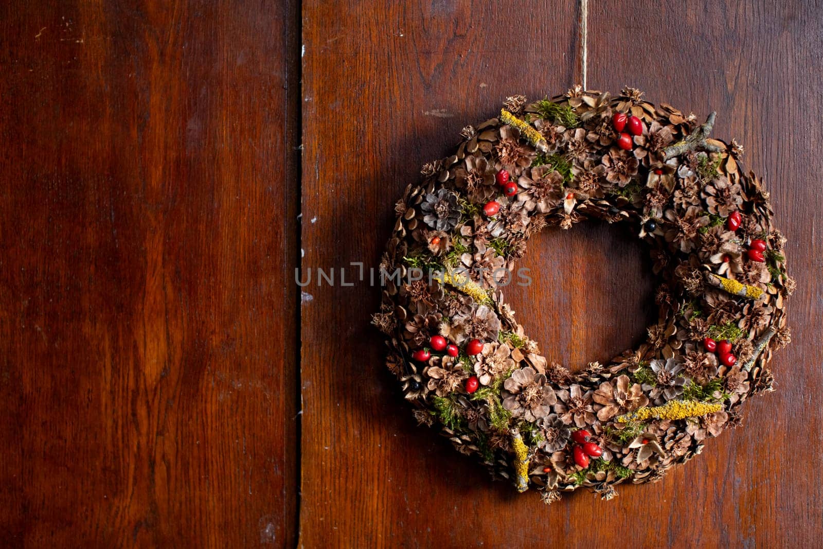 This beautiful festive wreath is adorned with various natural elements, making it perfect for holiday decoration