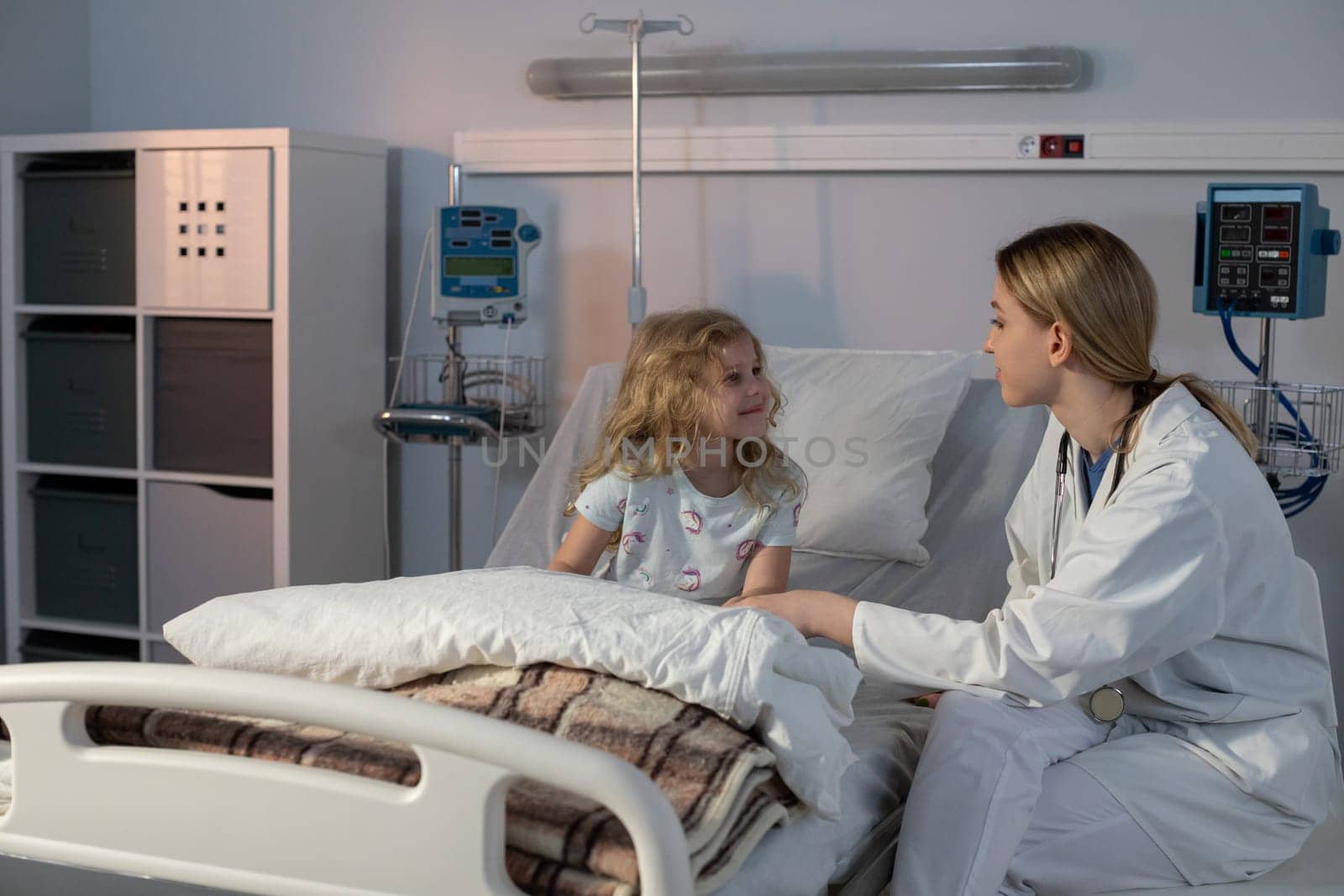 A compassionate doctor engages with a young patient, fostering comfort and trust in a hospital setting.