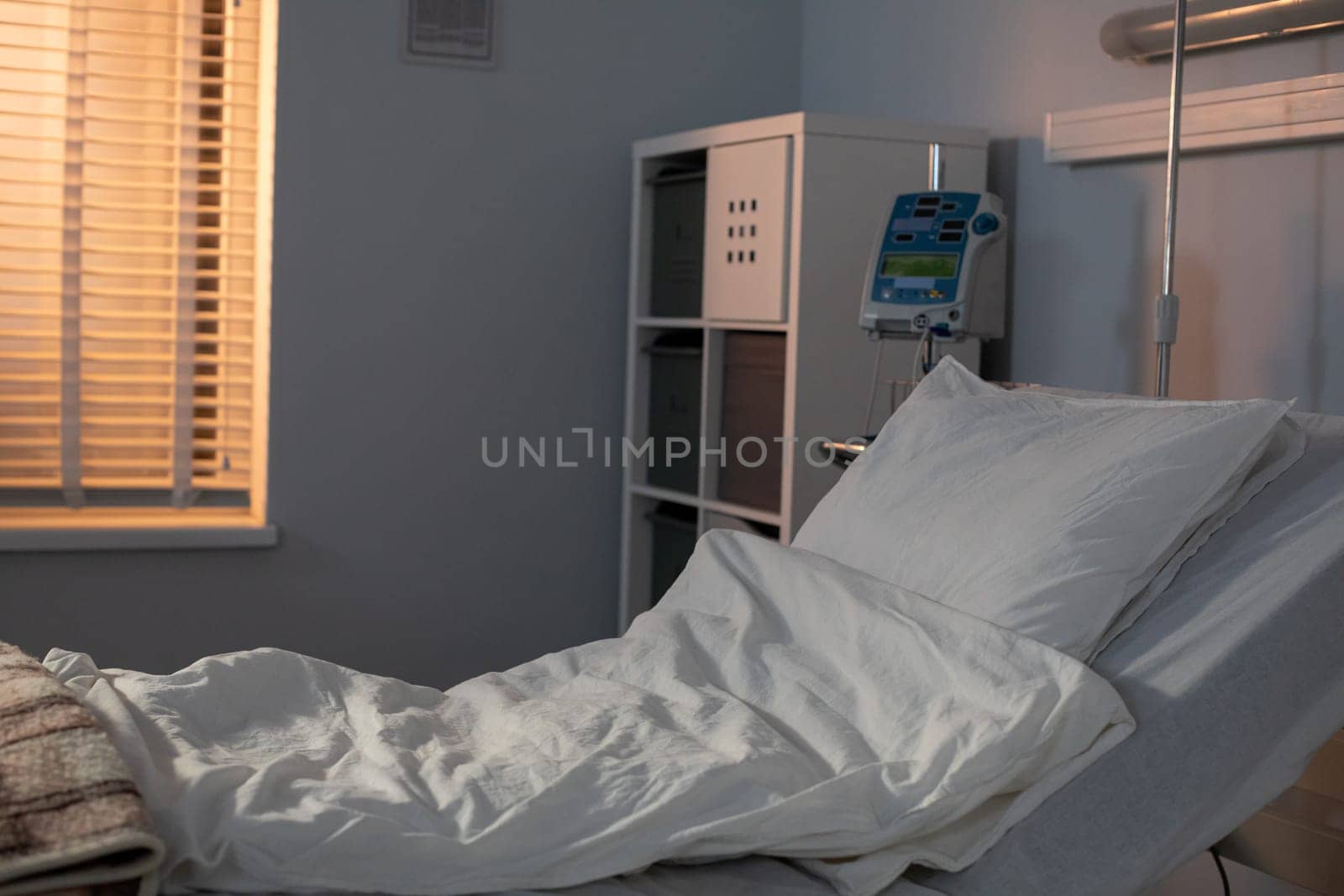 A tranquil and serene hospital room showcasing a neatly made bed and the presence of soft natural light