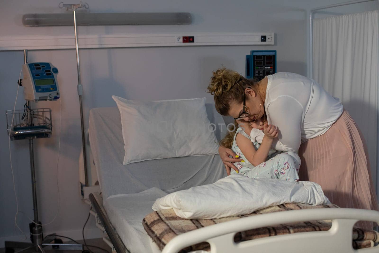 In a hospital setting, a profoundly touching moment unfolds as a mother lovingly embraces her child