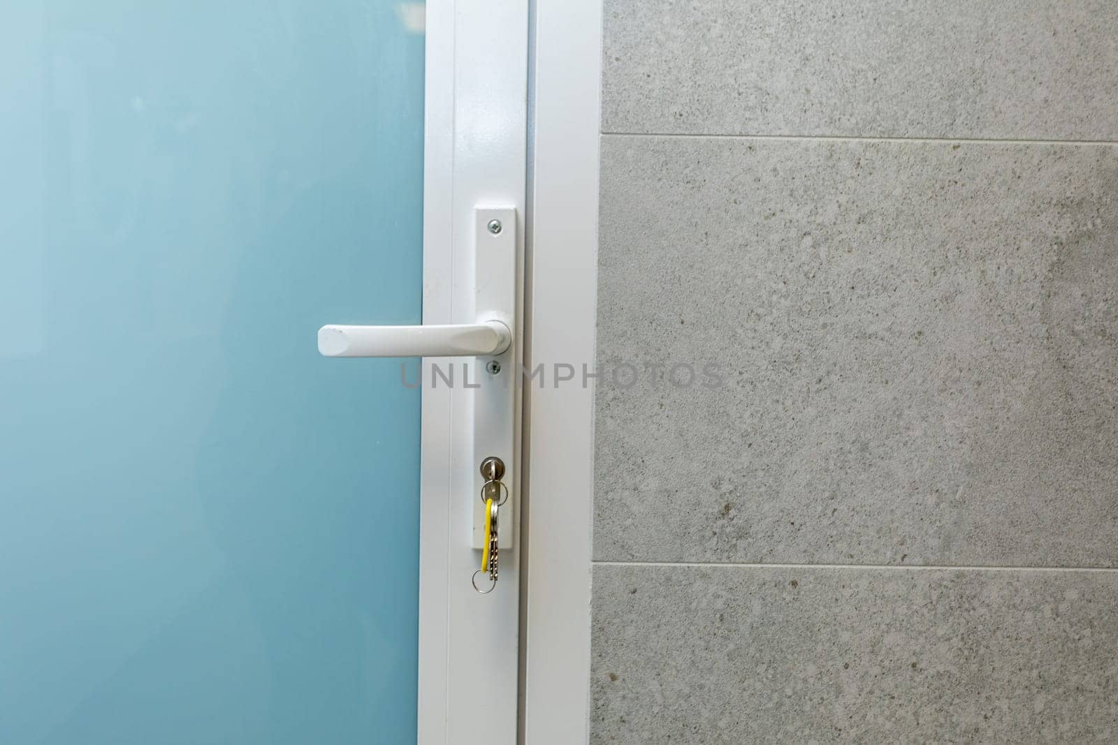 A closeup view of a modern door handle set against a textured wall, drawing attention to its sleek contemporary design