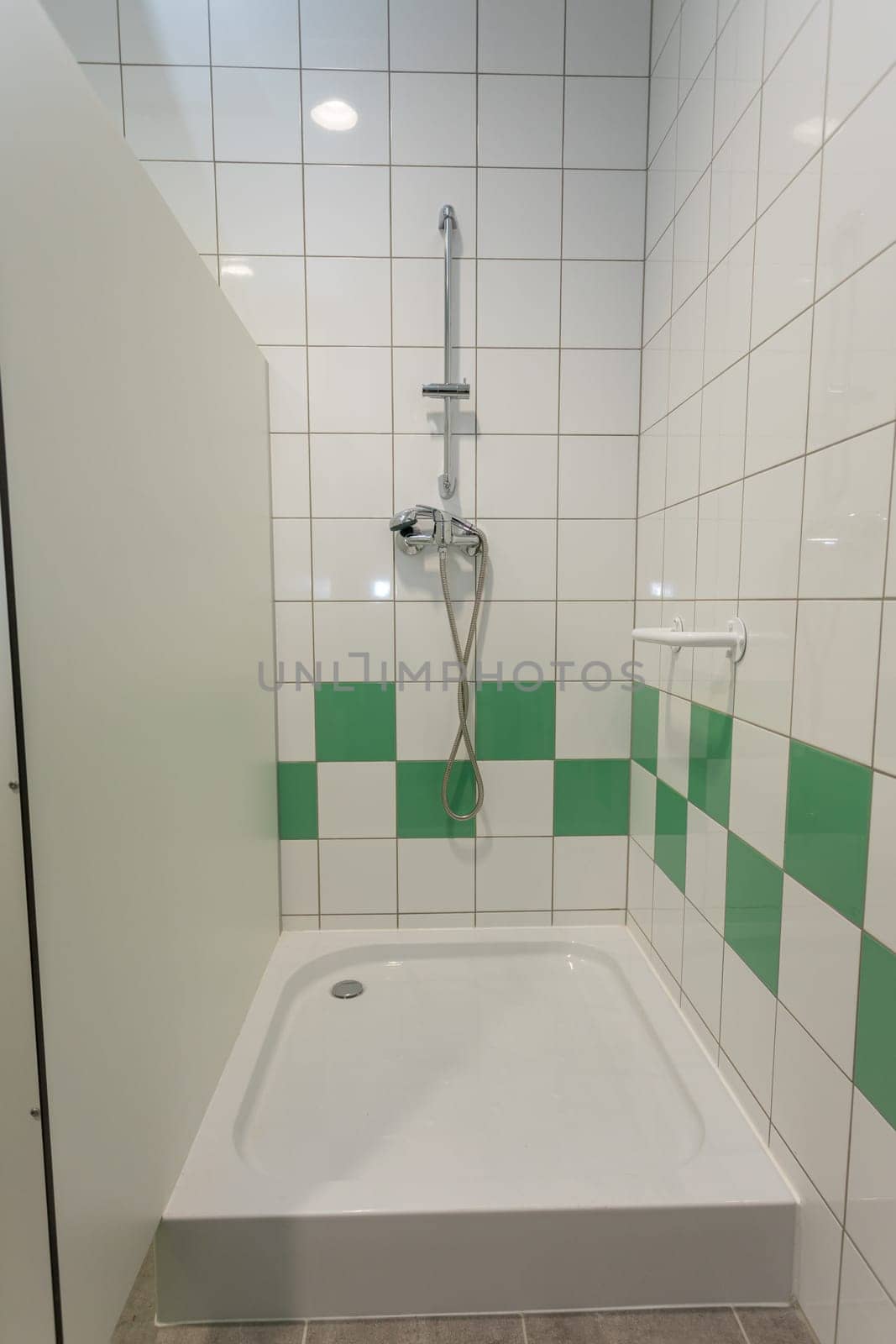 A contemporary shower area that showcases stunning green and white tiles, ideal for modern and sleek bathroom designs