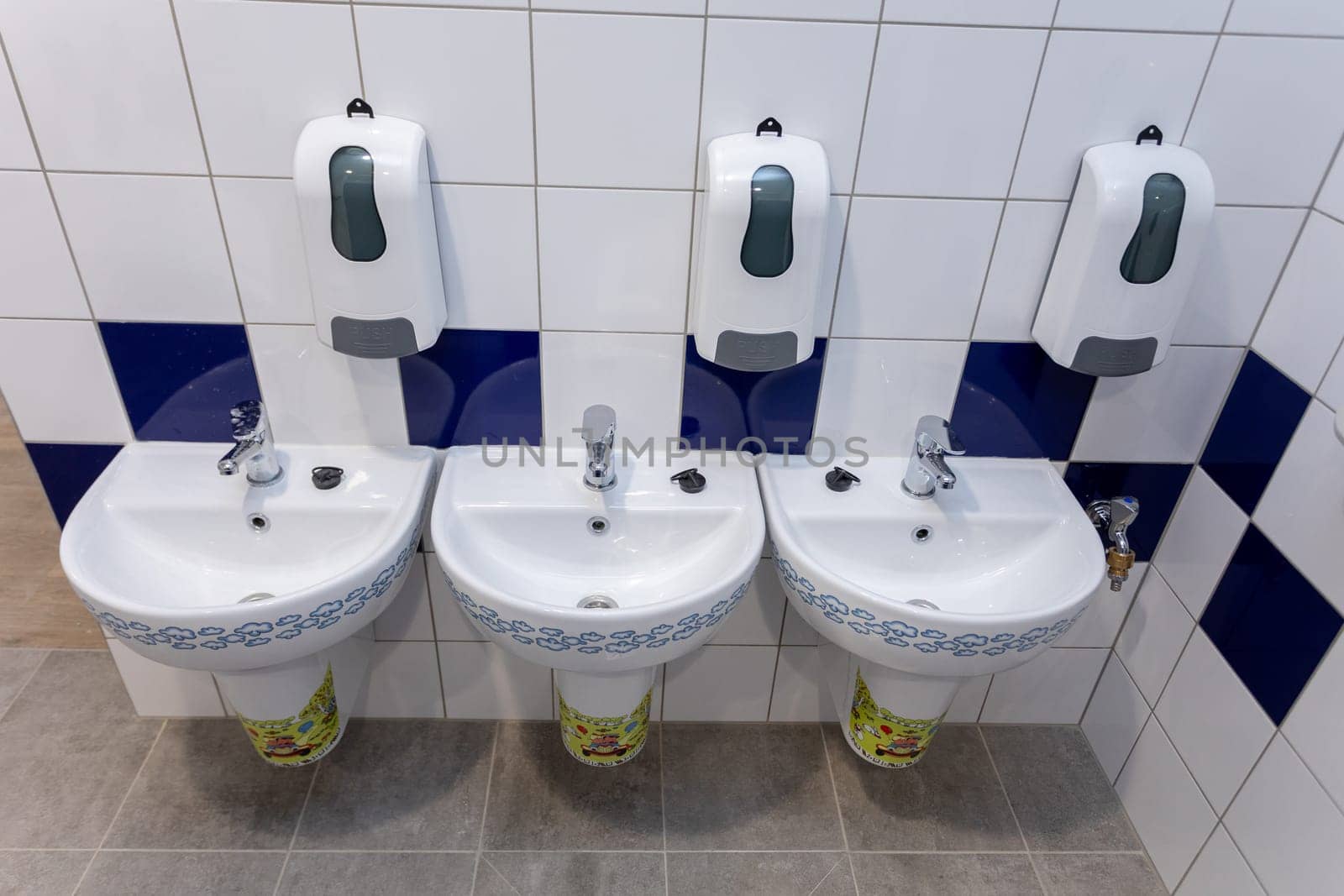 This stylish and functional bathroom setup showcases beautifully designed sinks along with handy soap dispensers