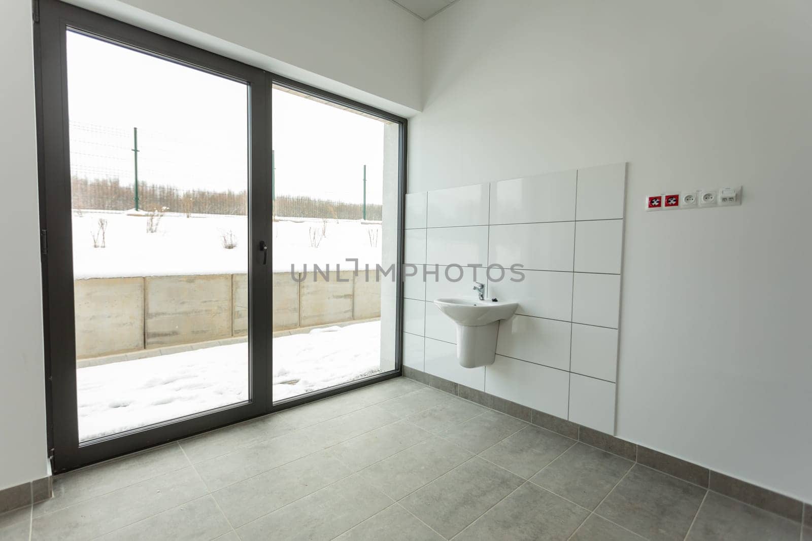 This room is clean and minimalistic, with a sink and expansive windows that showcase views of snowcovered grounds
