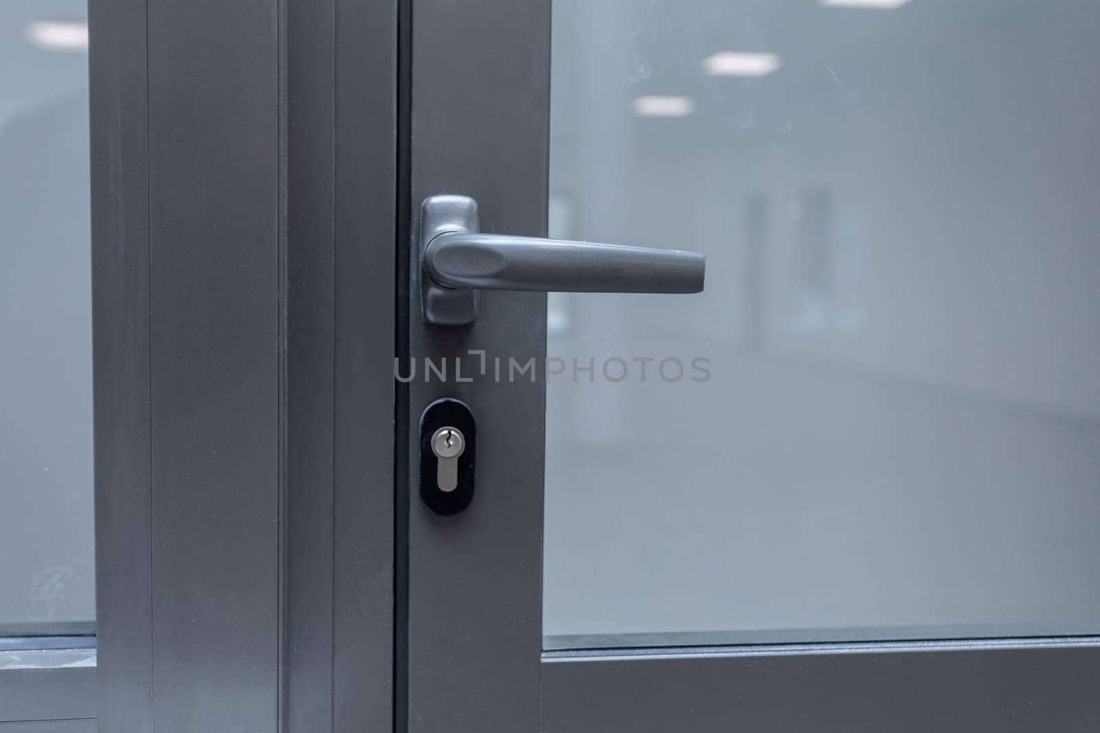 This sleek glass door features a minimalist design with a metal handle and a secure lock for safety