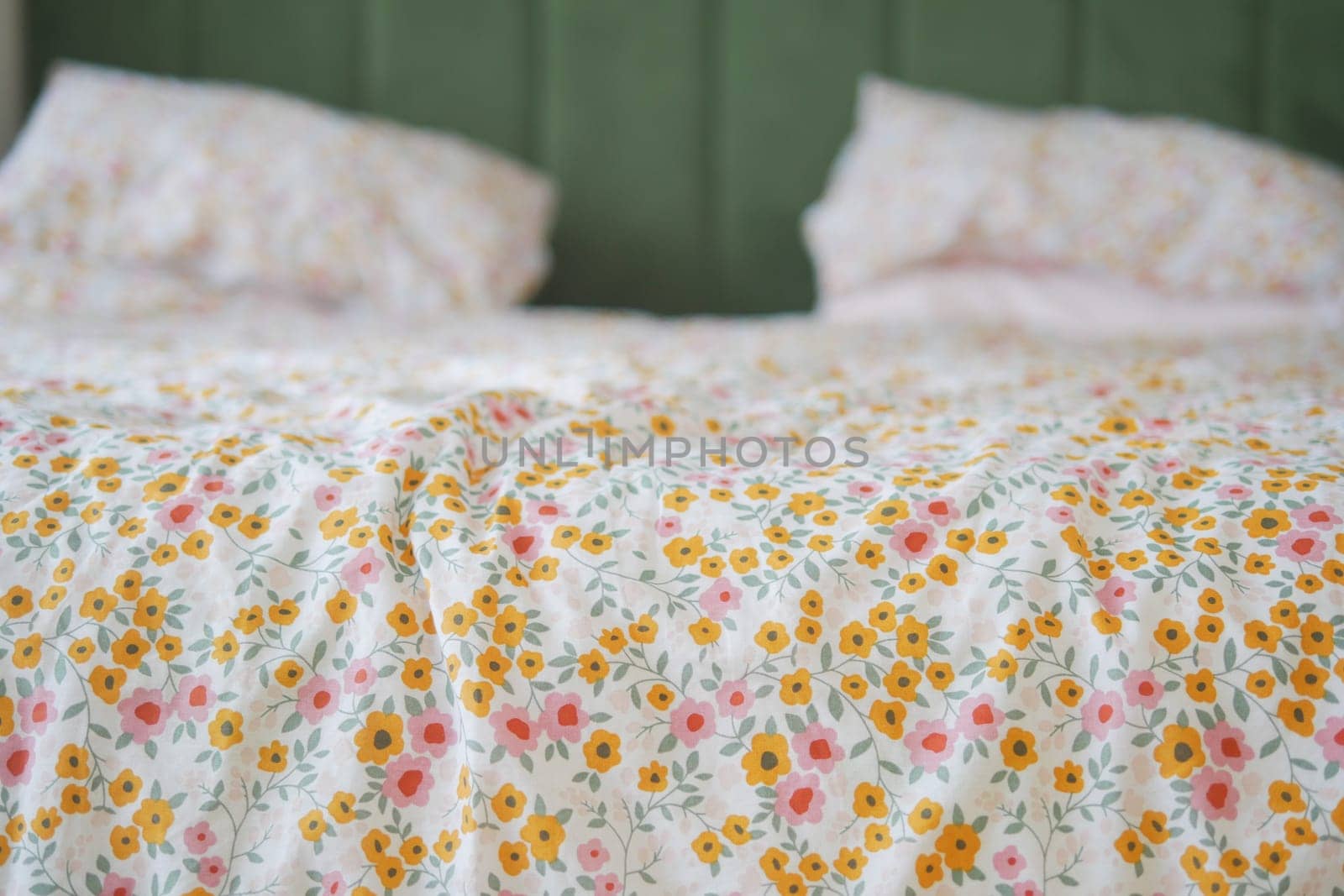 Brightly patterned bedding adorns a bed in a warm, inviting room setting.
