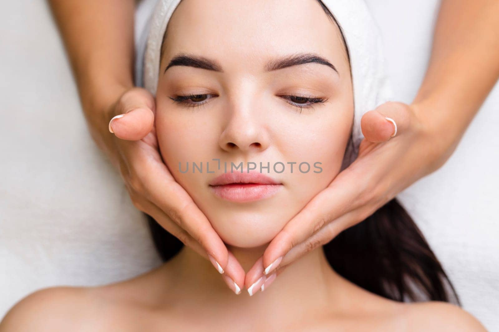 Professional anti-aging facial massage. Action. Relaxing facial treatment at Spa. Relaxing and rejuvenating facial massage for women.