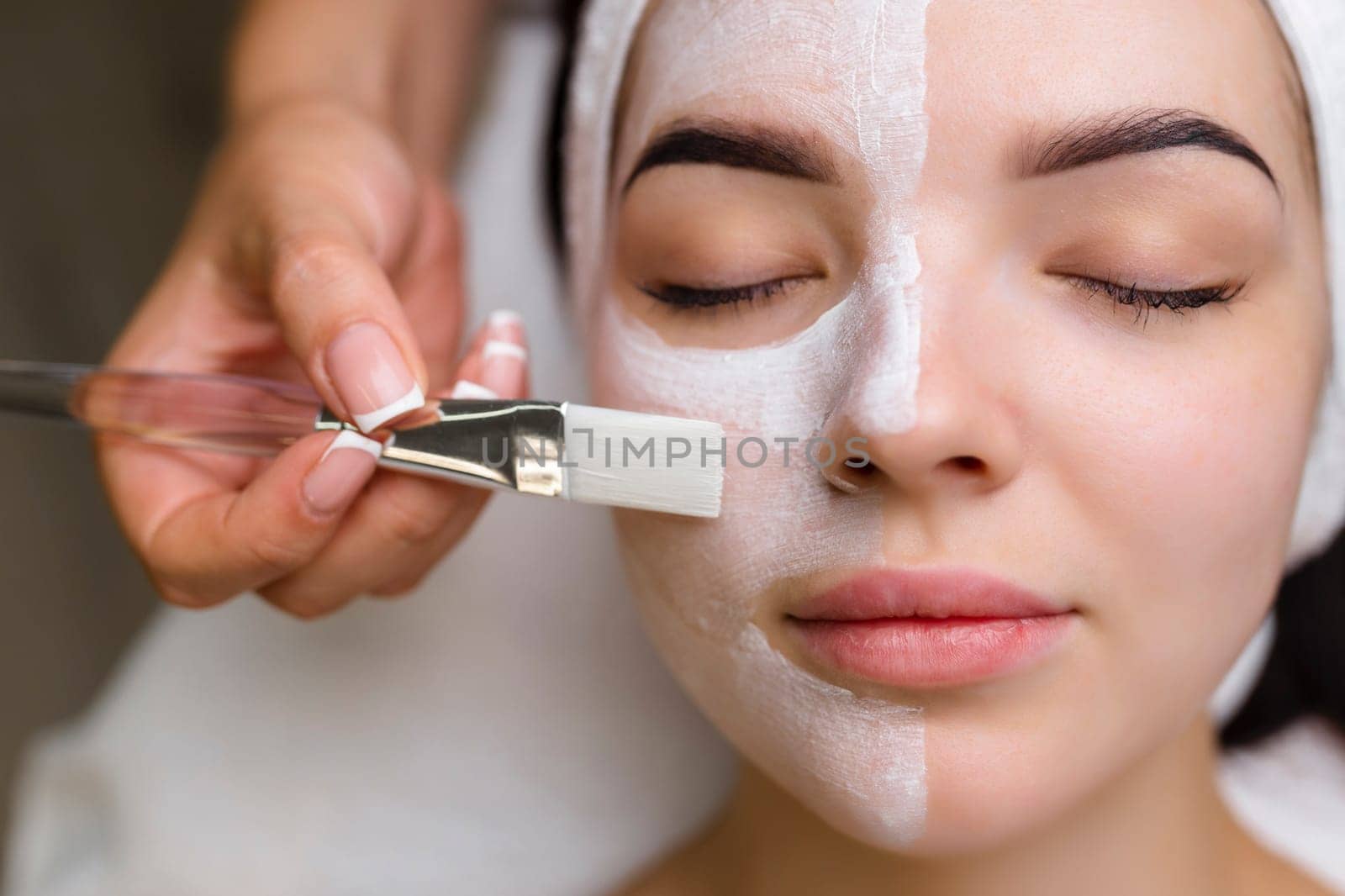 Close-up shot of a woman getting facial treatment with clay mask. Cosmetology and spa. High quality 4k footage