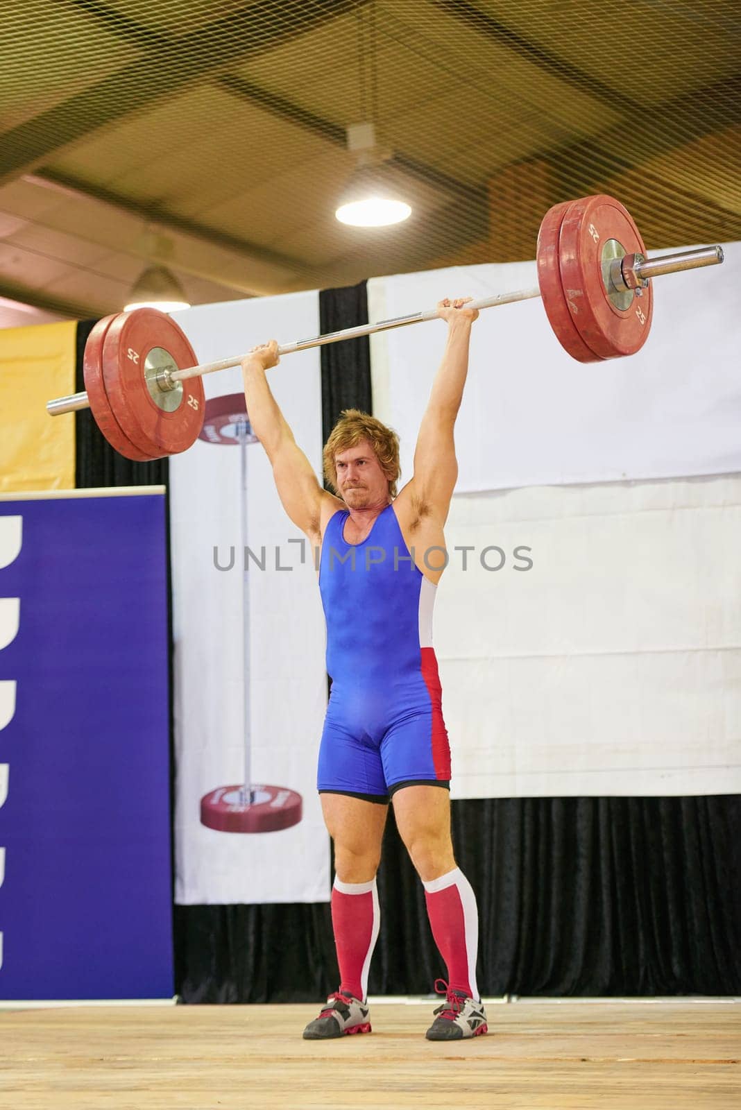 A weight lifter lifting weights during a competition