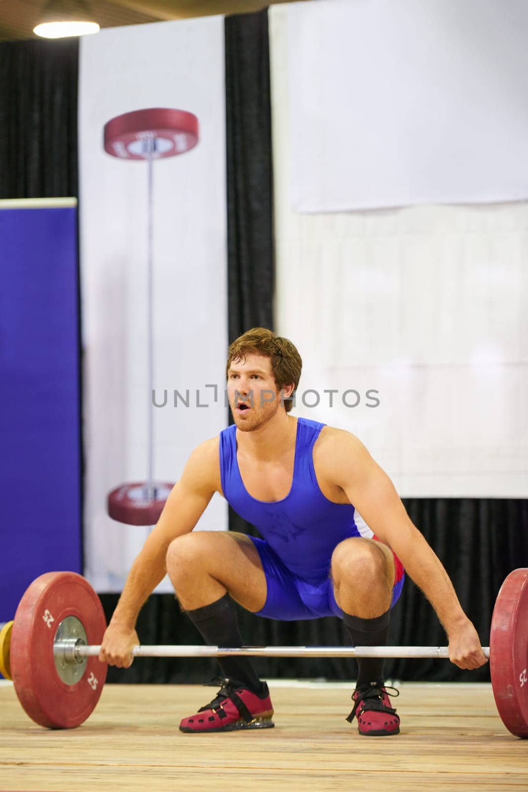 A weight lifter lifting weights during a competition