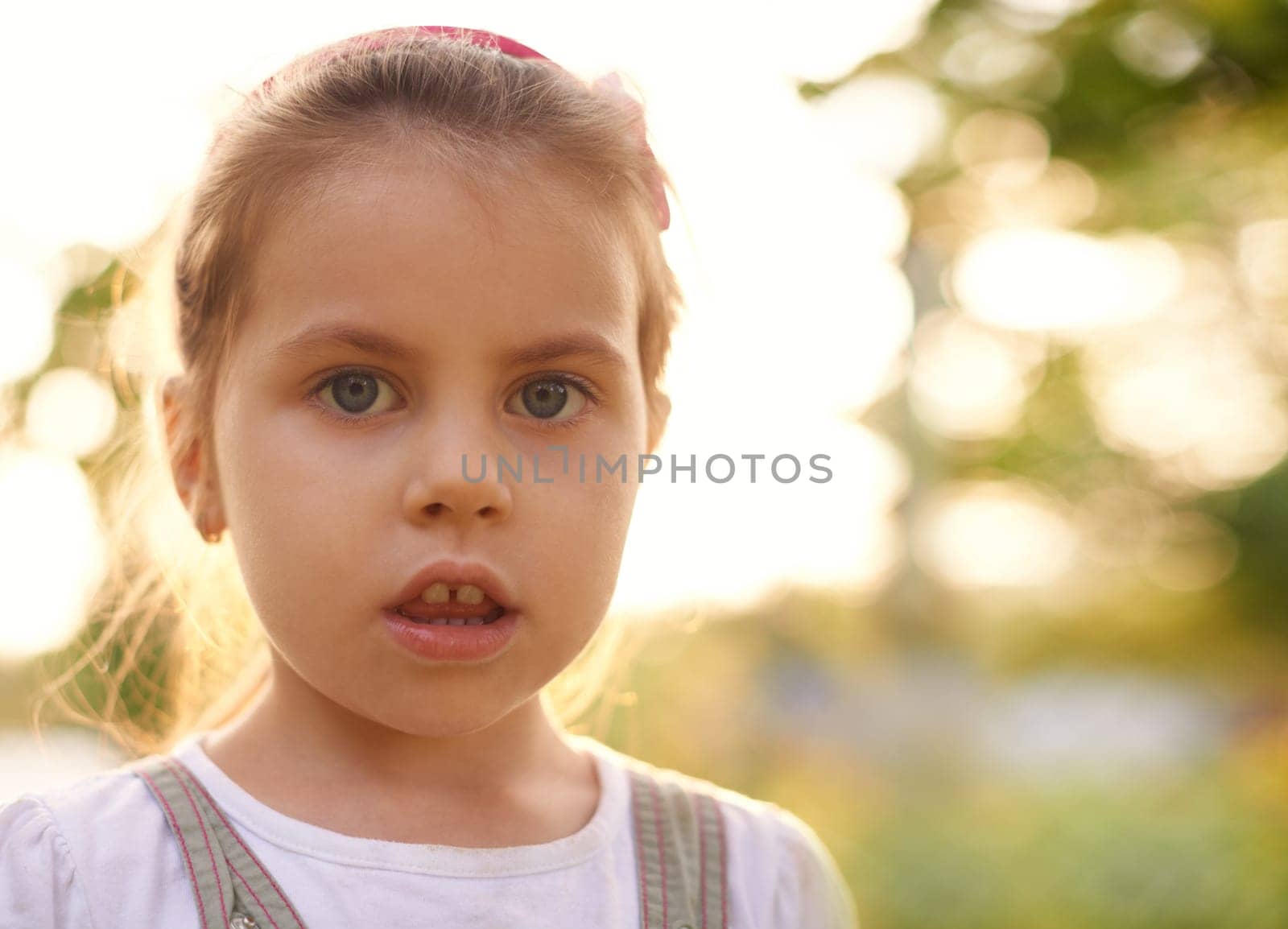 Closeup candid portrait of a little girl gazing innocently at the camera
