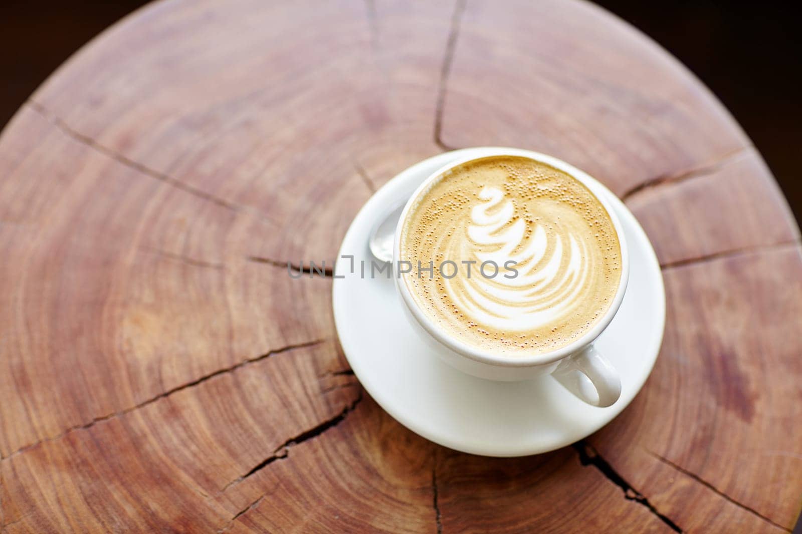 Closeup of a cappucino on a wooden stump with beautiful natural patterns
