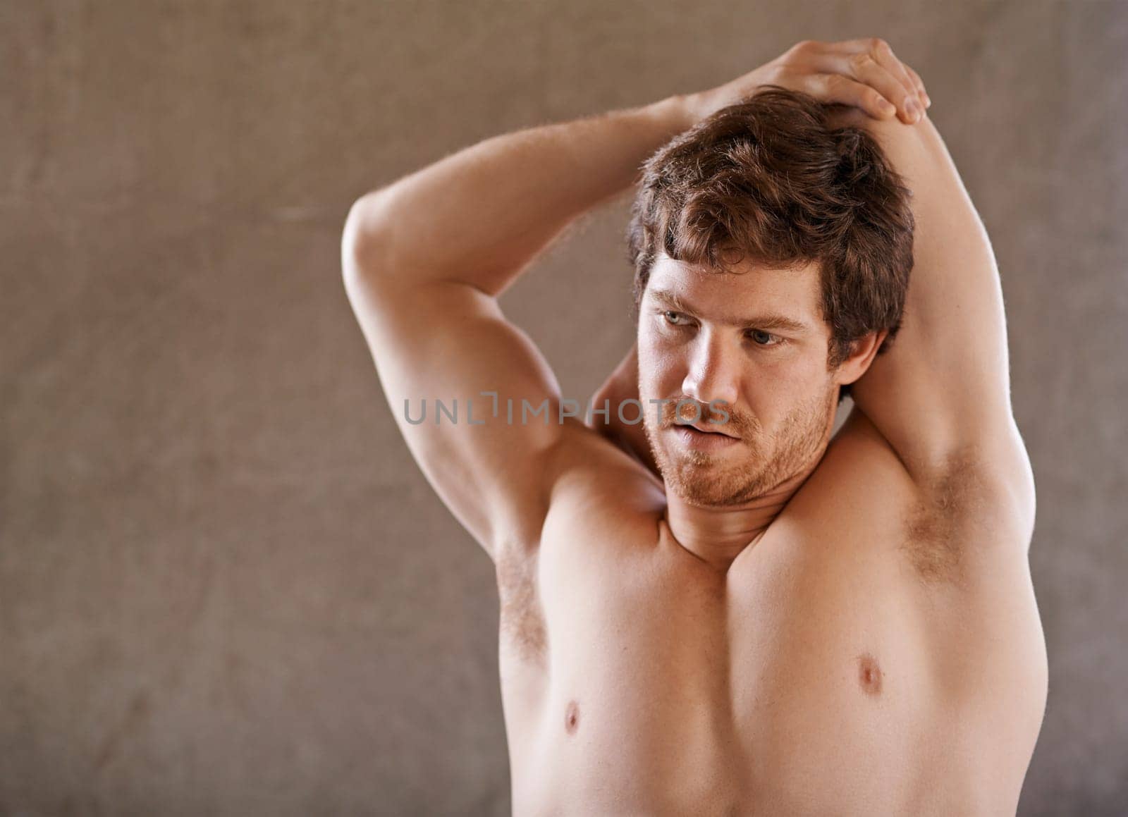 Strong young man warming up his arm muscles in preparation for a gym workout