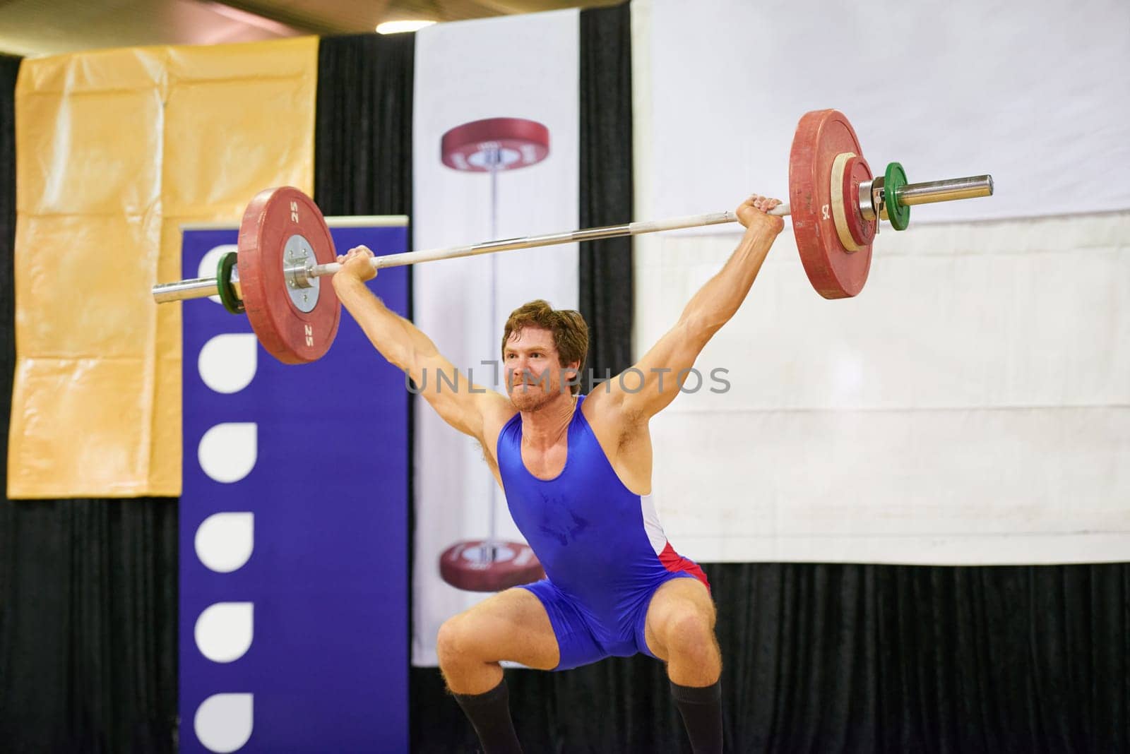 A weight lifter lifting weights during a competition