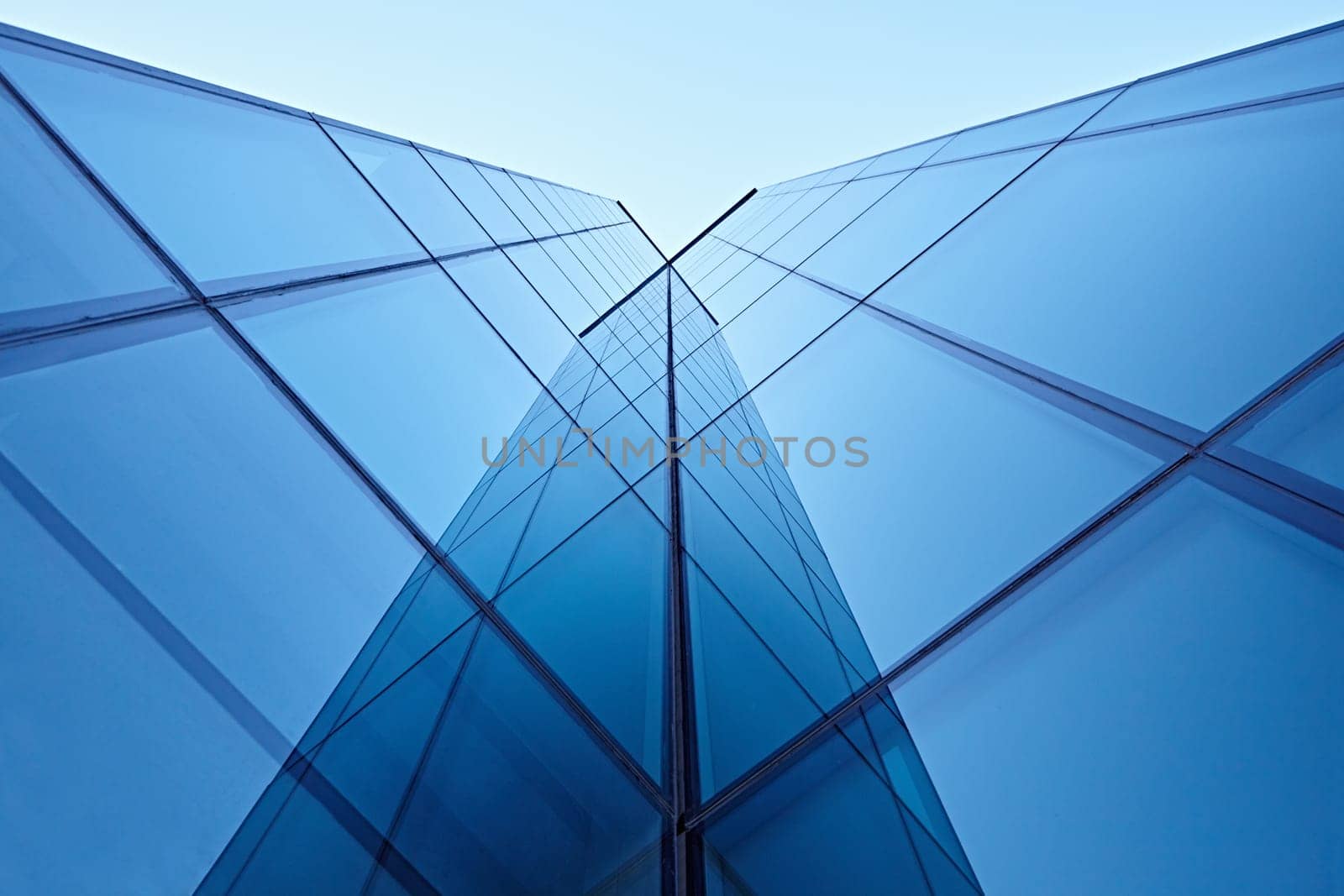 Abstract image of the facade of a modern high rise building covered in reflective plate glass