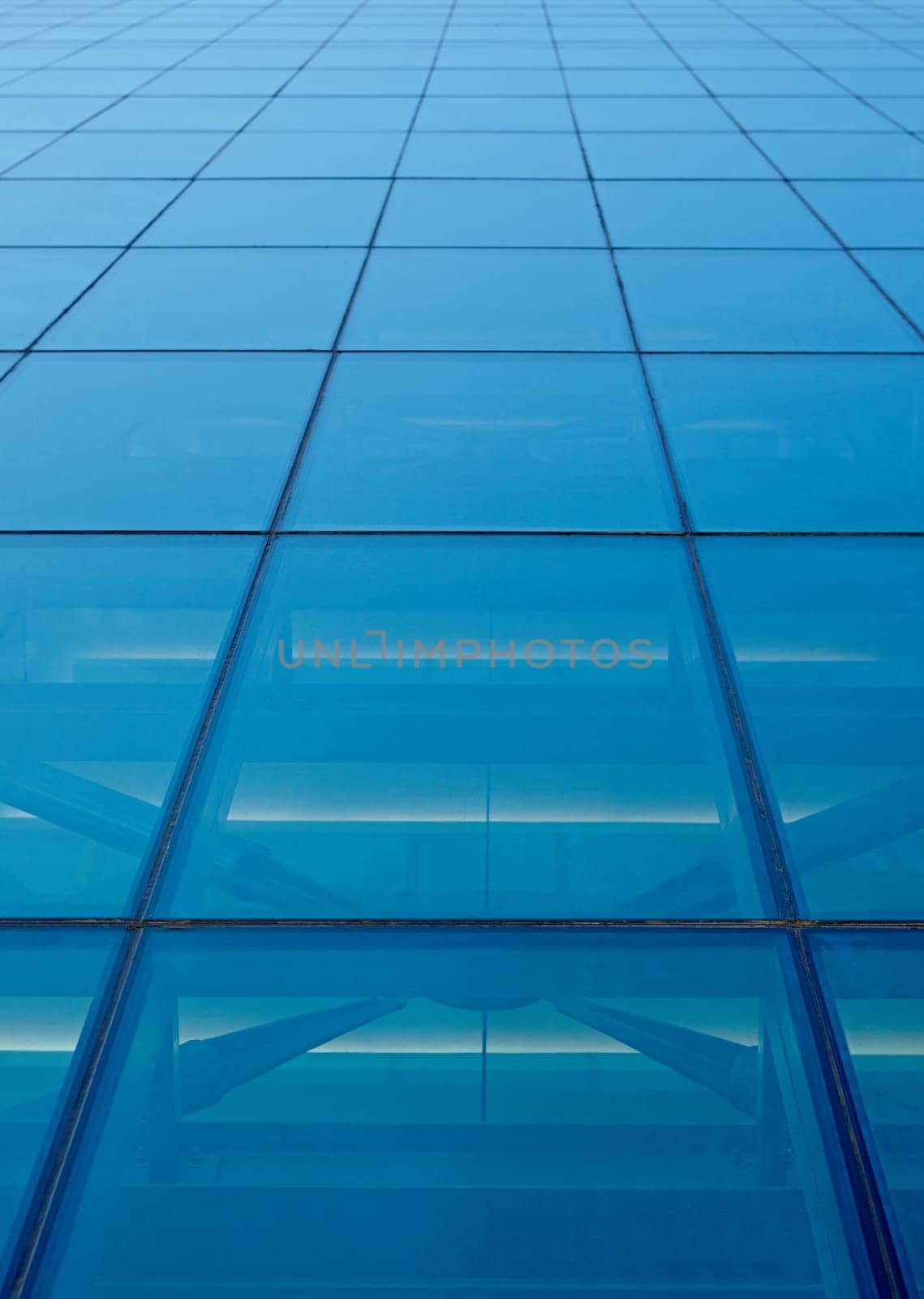 Abstract closeup of the glass-clad facade of a modern building covered in reflective plate glass
