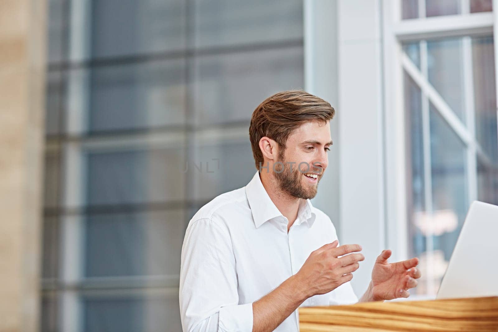 Young businessman engaged in a conversation on his laptop in a corporate setting