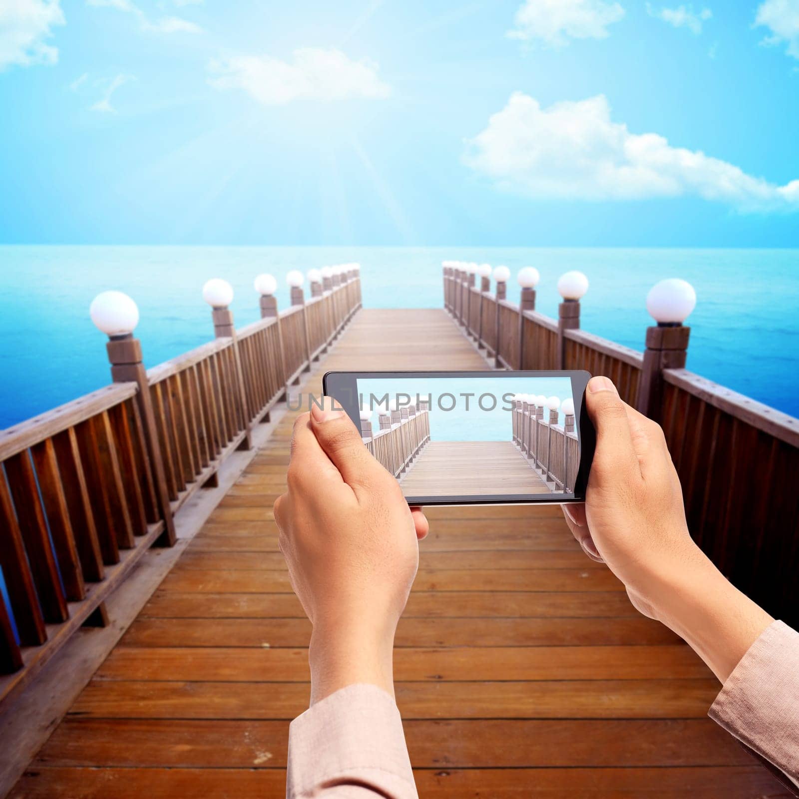 Man hand take picture of wooden pier using cellphone. Tourism concept photo