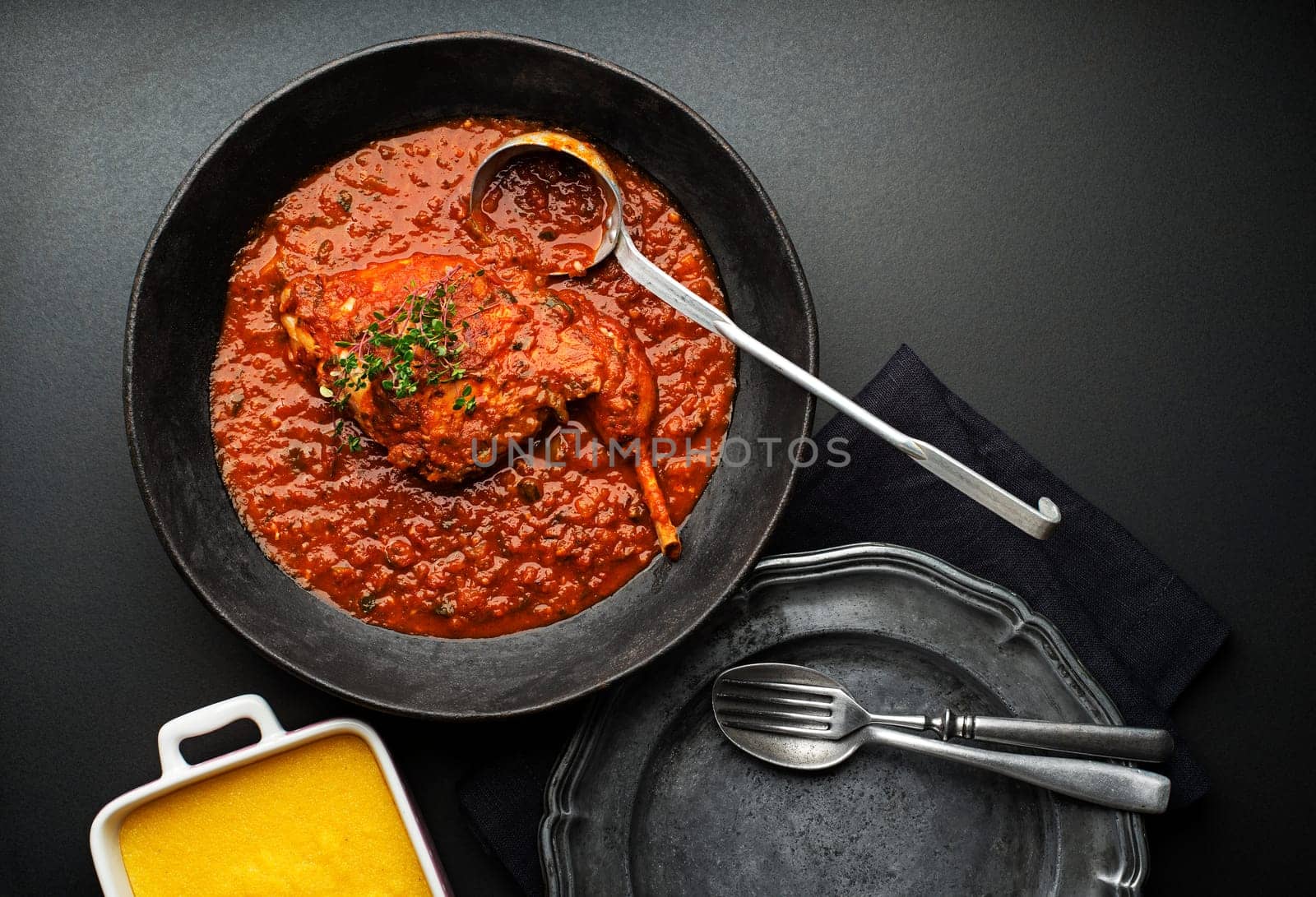 Meat stew with vegetable and tomato sauce on black background