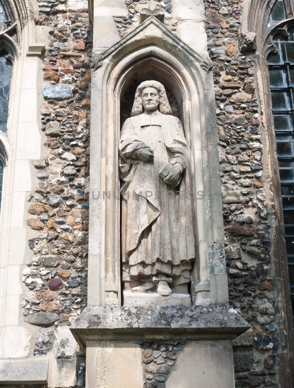 statue of judge man on the outside of english christian church made of stone Essex  England  UK