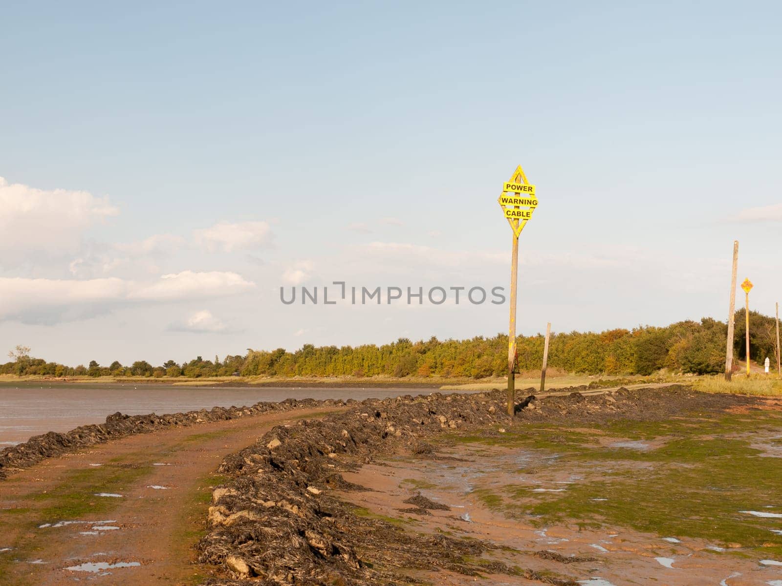 old vintage sign power warning cable pole yellow landscape island black water Maldon Essex  England  UK