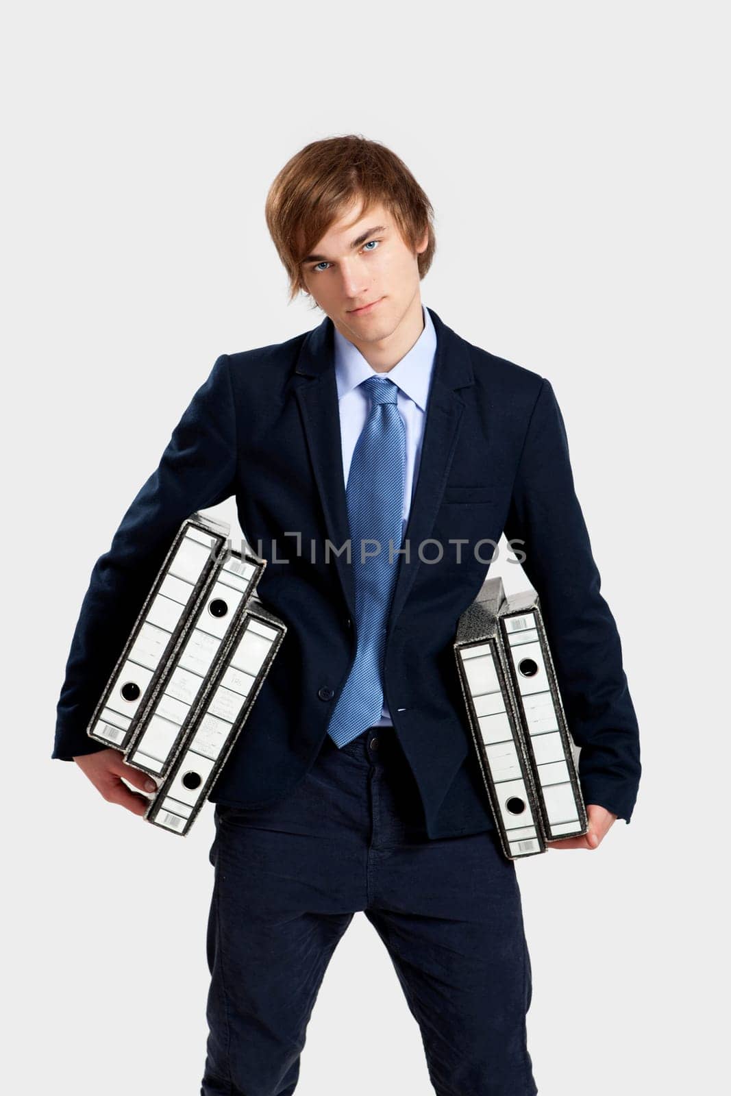 Young business man carrying a bunch of folders