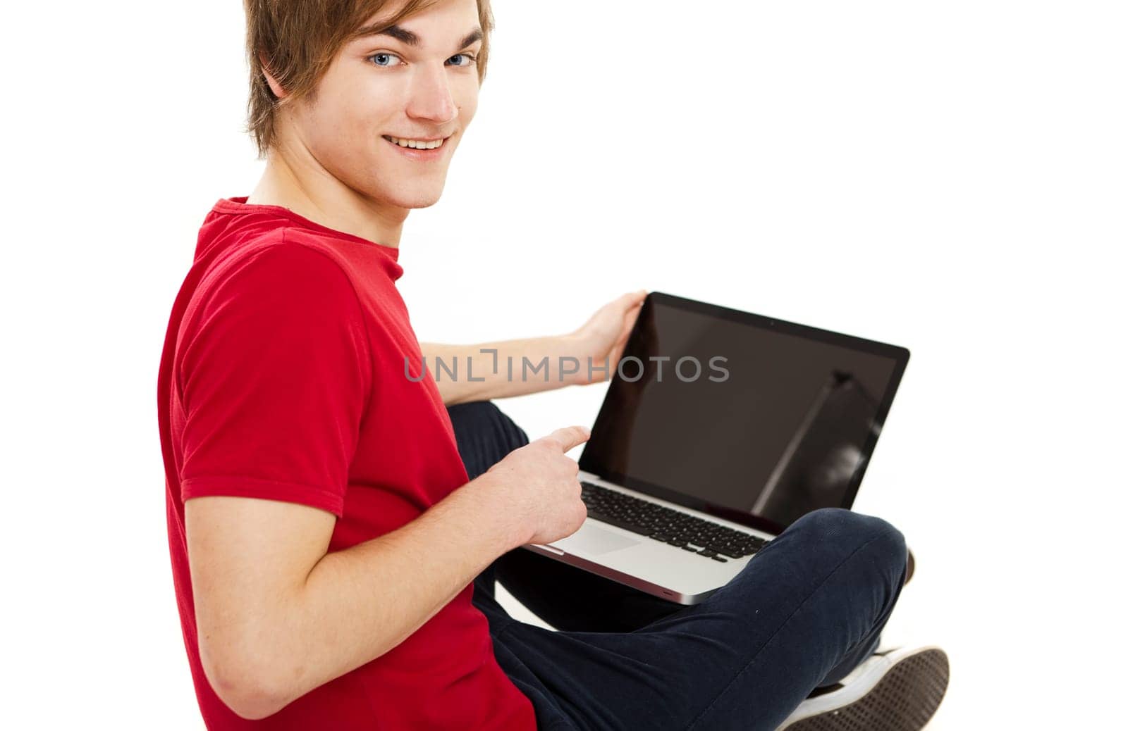 Handsome young man at home sitting on the couch and working on the laptop