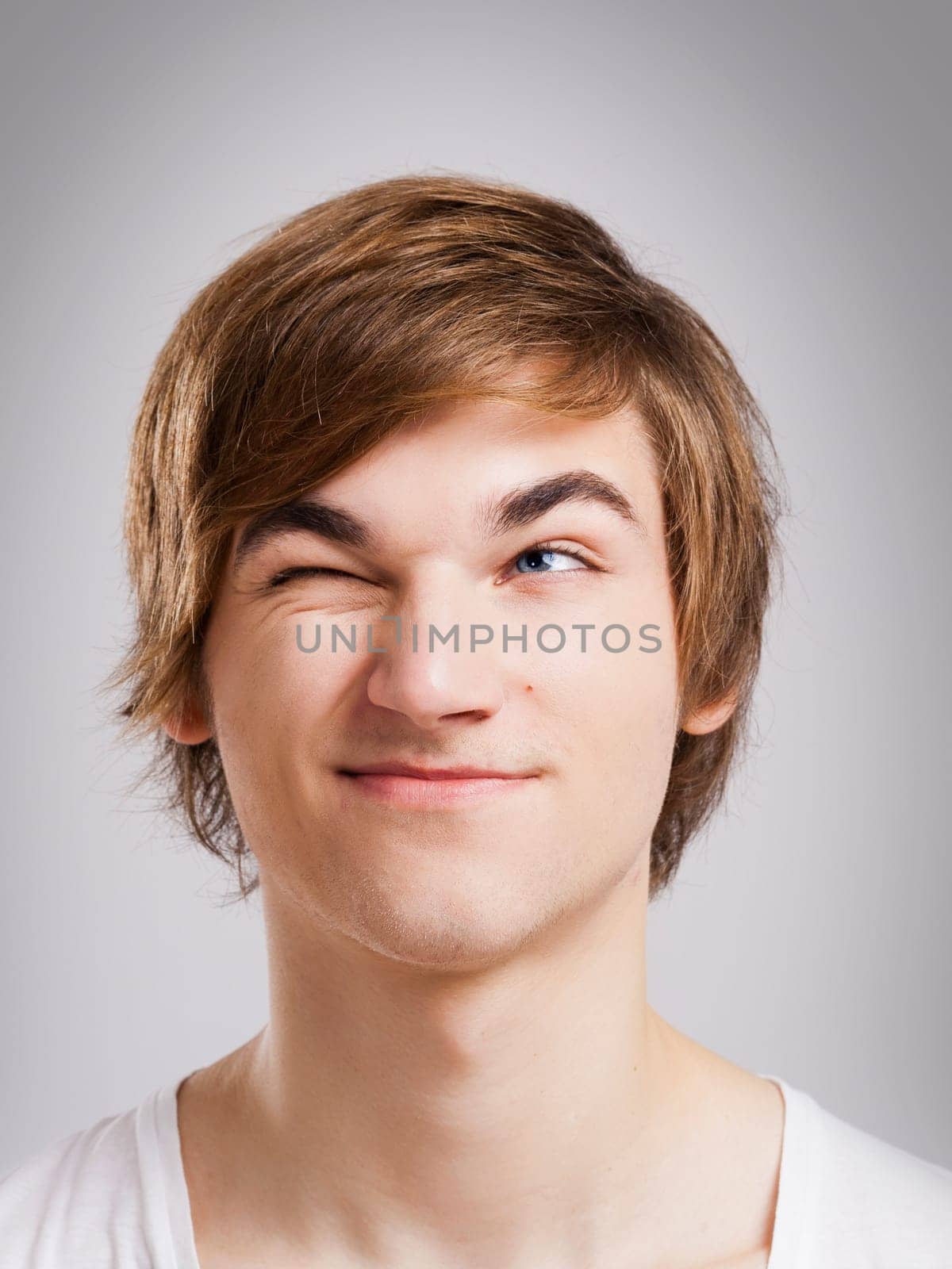 Portrait of a handsome young man looking up and laughing