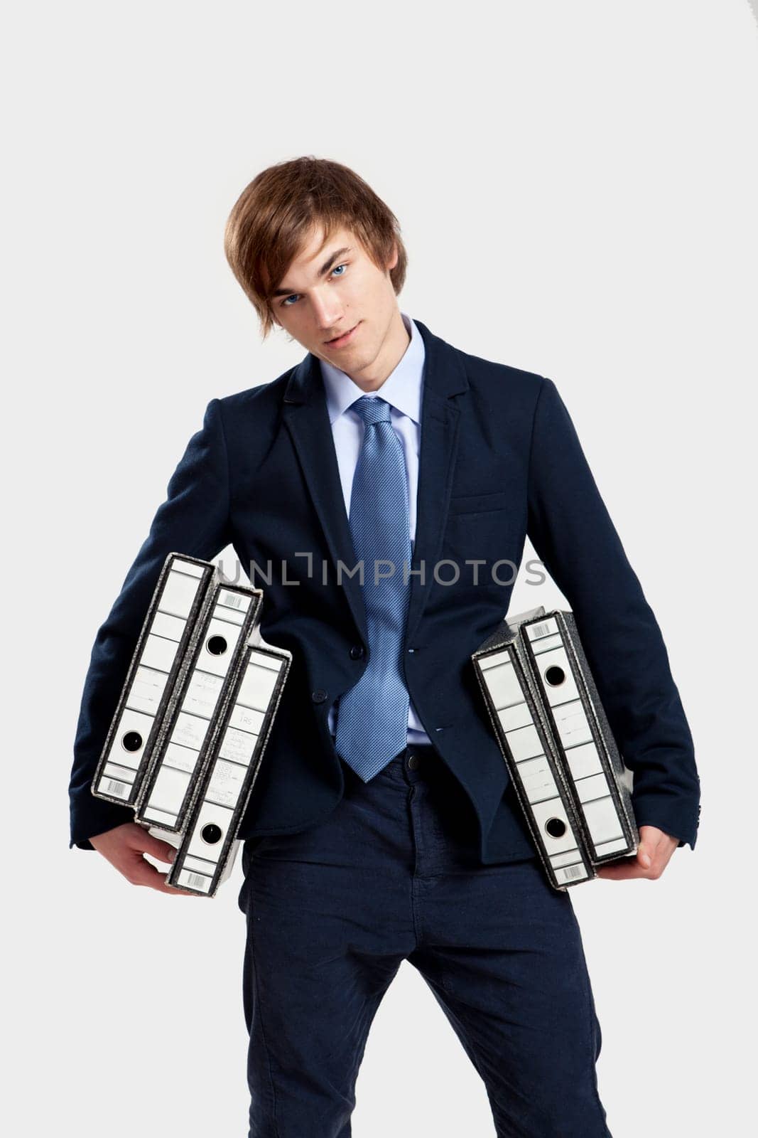 Young business man carrying a bunch of folders