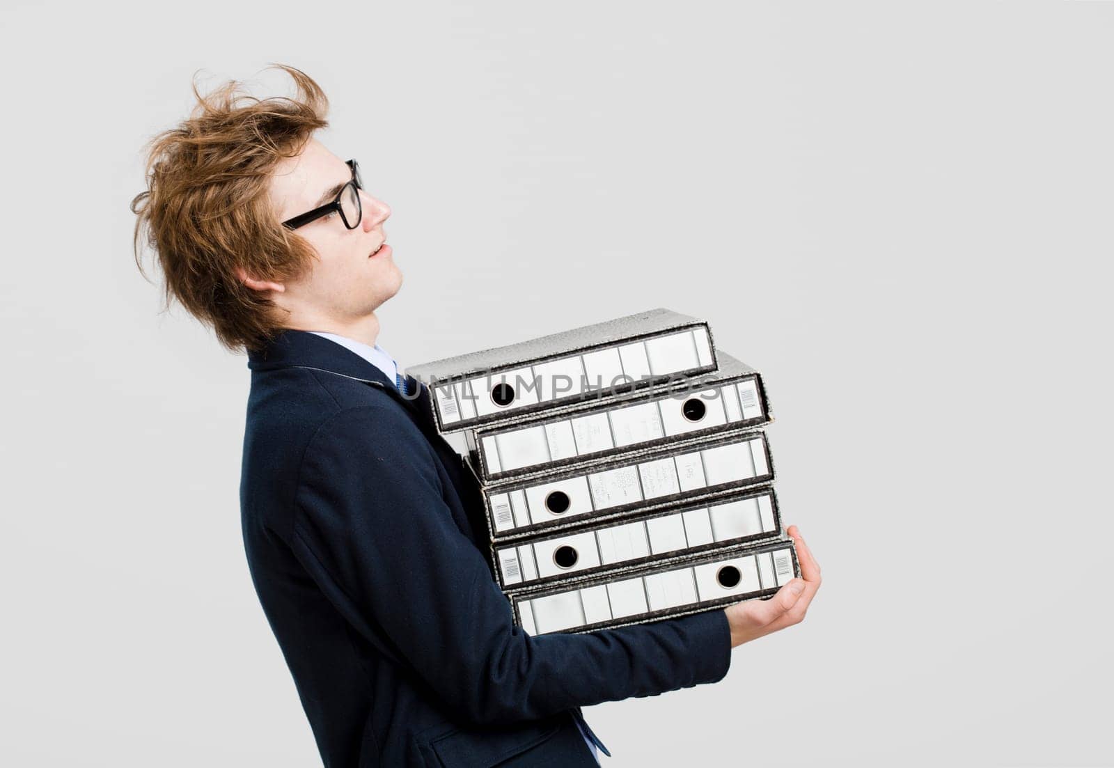 Young business man carrying a bunch of folders