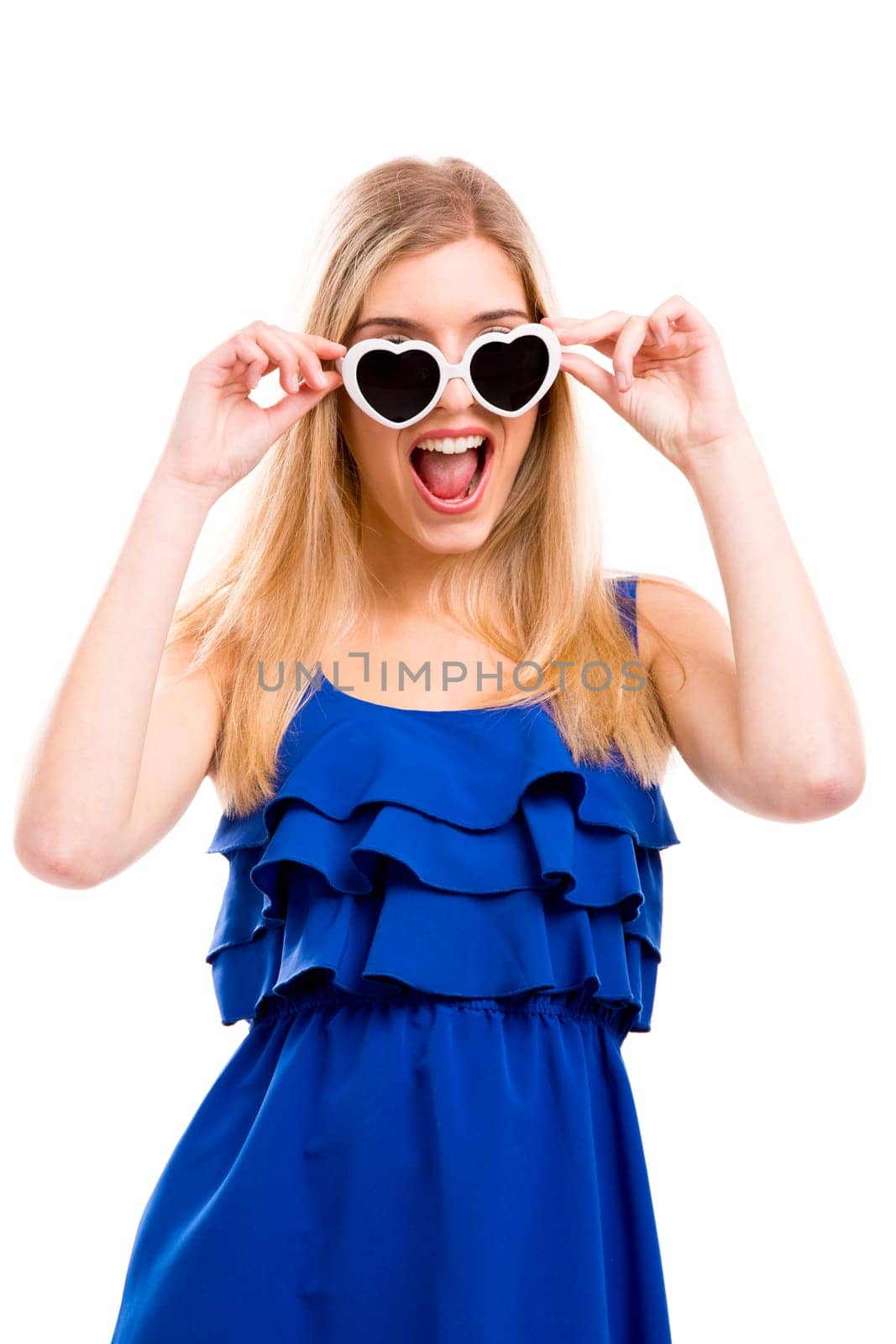 Beautiful woman in blue dress using sunglasses with a hearth shape, isolated over white background
