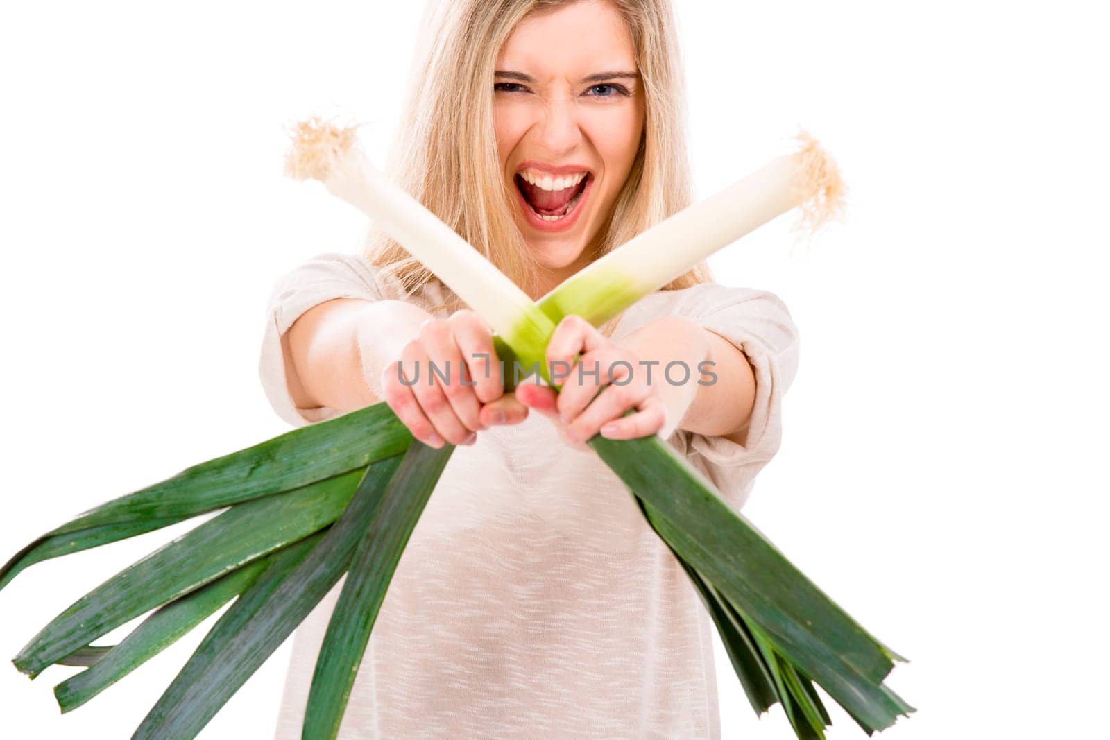 Beautiful blonde woman holding leeks and fighting with them