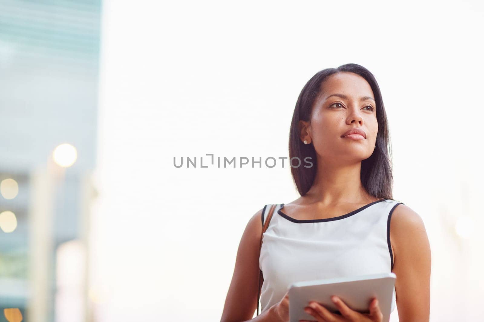 A young businesswoman working on her tablet outdoors