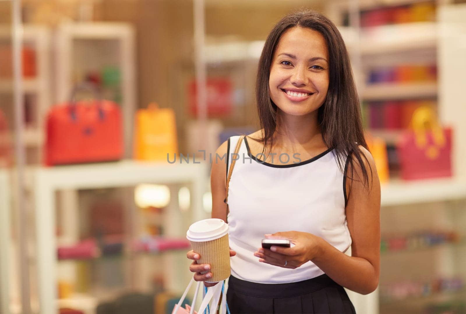 A beautiful young woman sending a text message in a mall