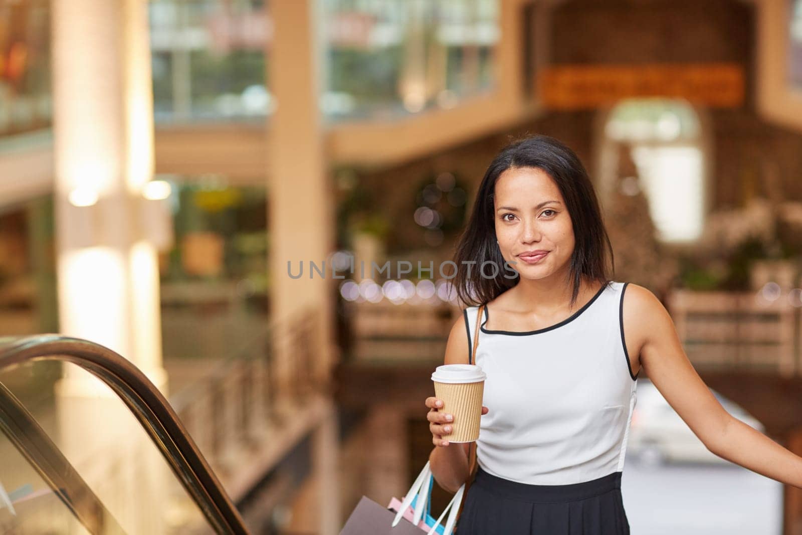 A young woman riding the escalator in a shopping mall