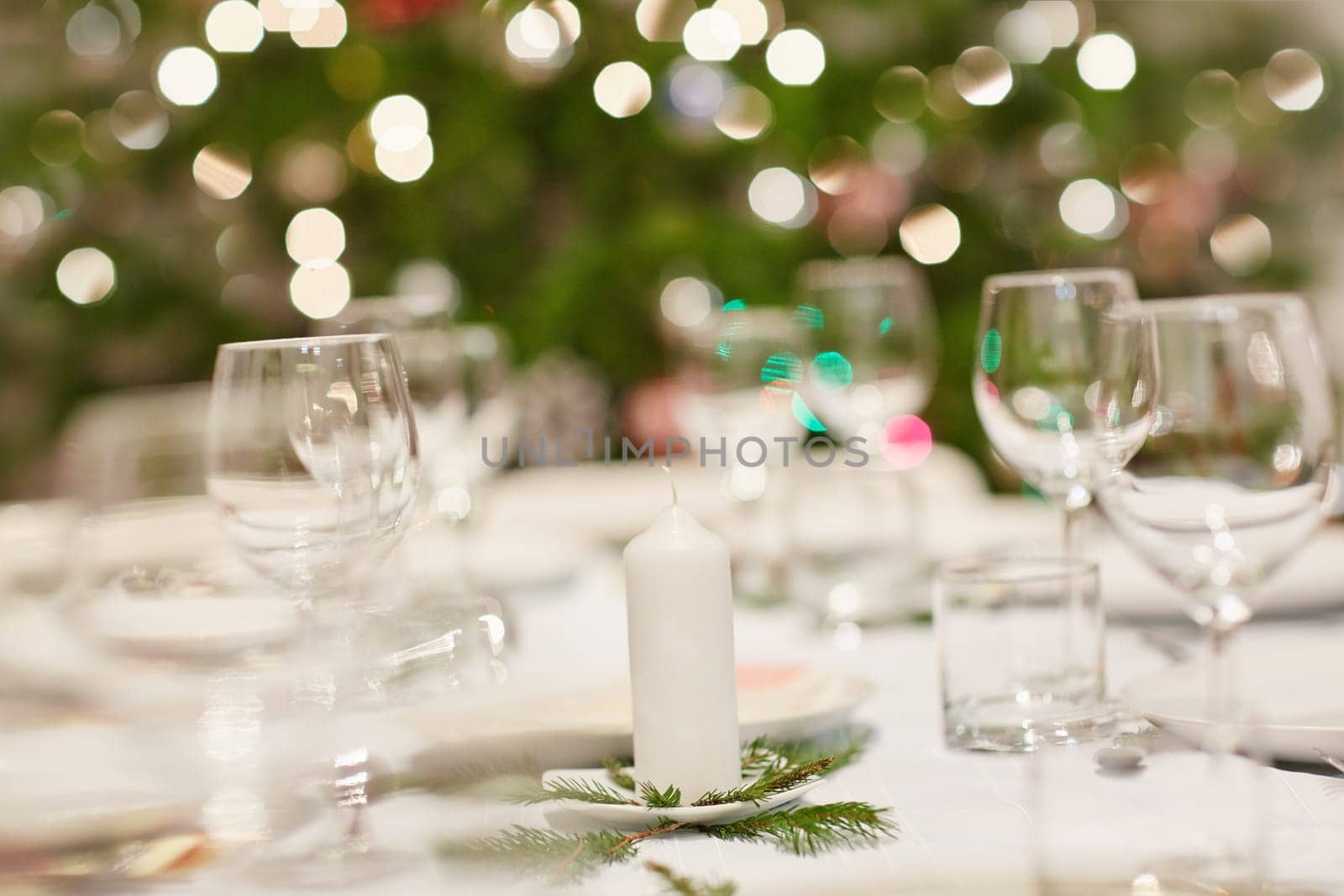 Closeup shot of a table set with glassware, plates and cutlery for a Christmas dinner