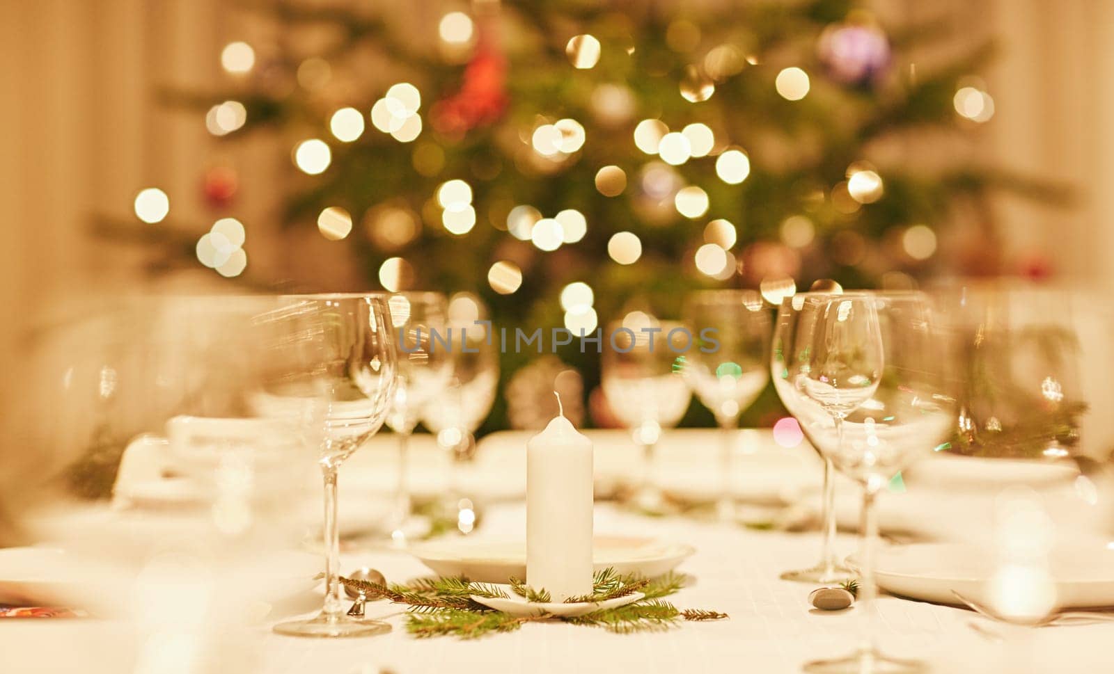 Closeup of a christmas candle on a festive table with bokeh in the background