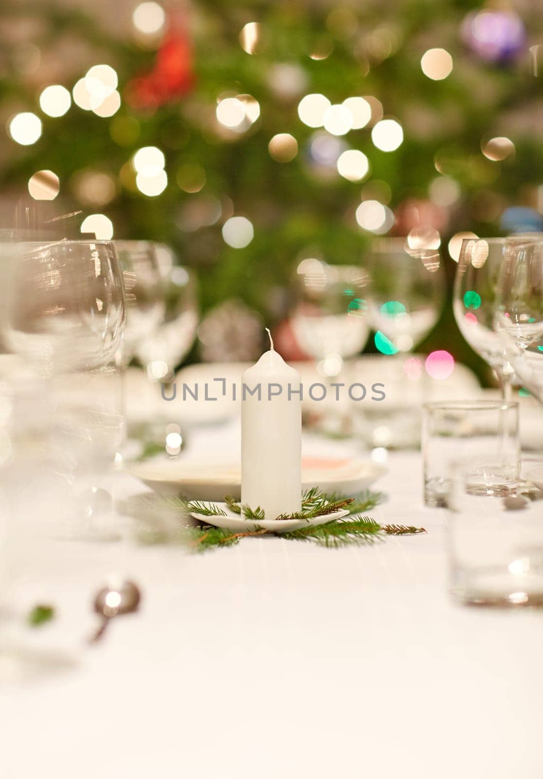 Closeup shot of a table set with glassware, plates and cutlery for a Christmas dinner