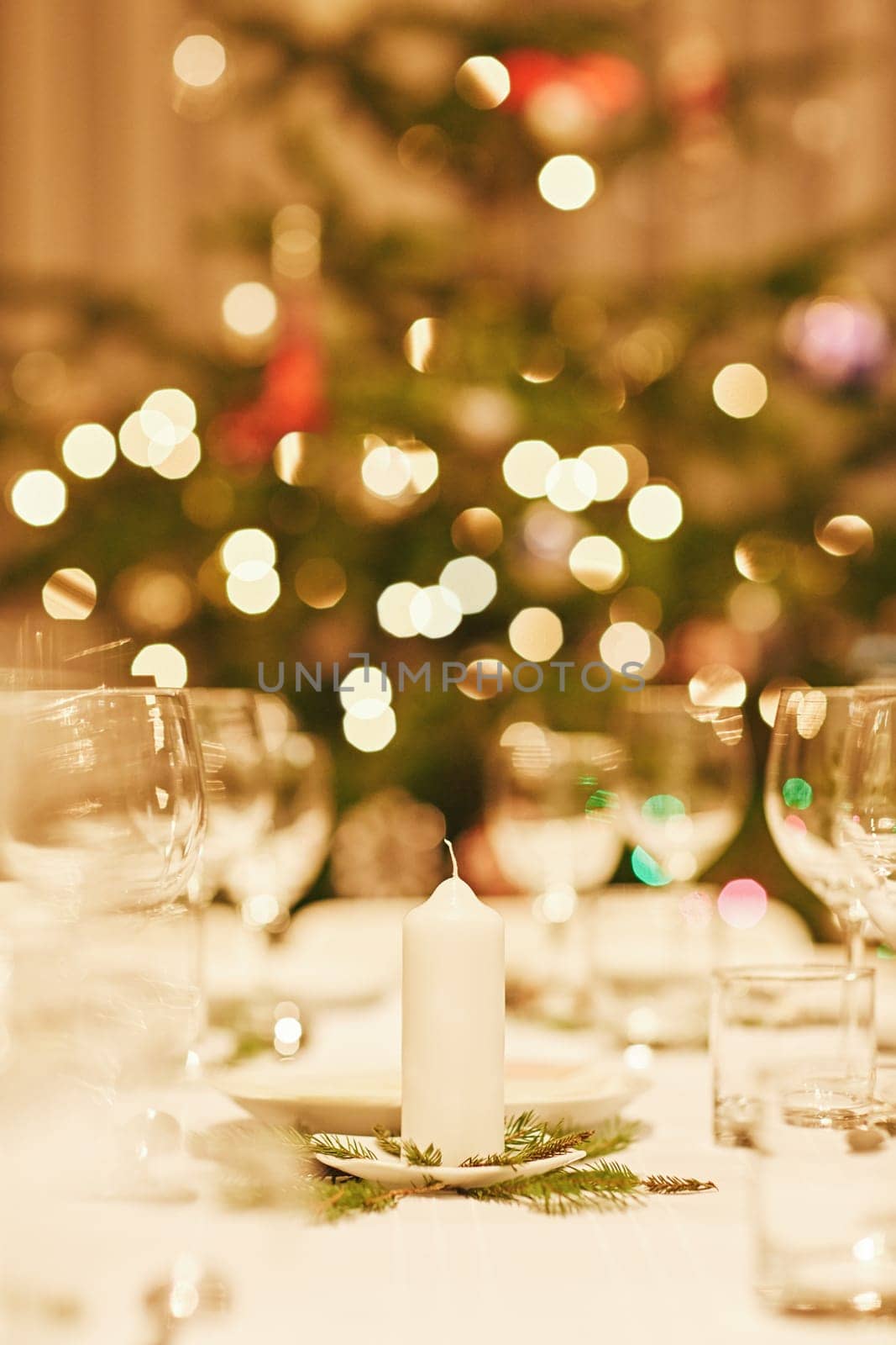 Closeup of a christmas candle on a festive table with bokeh in the background